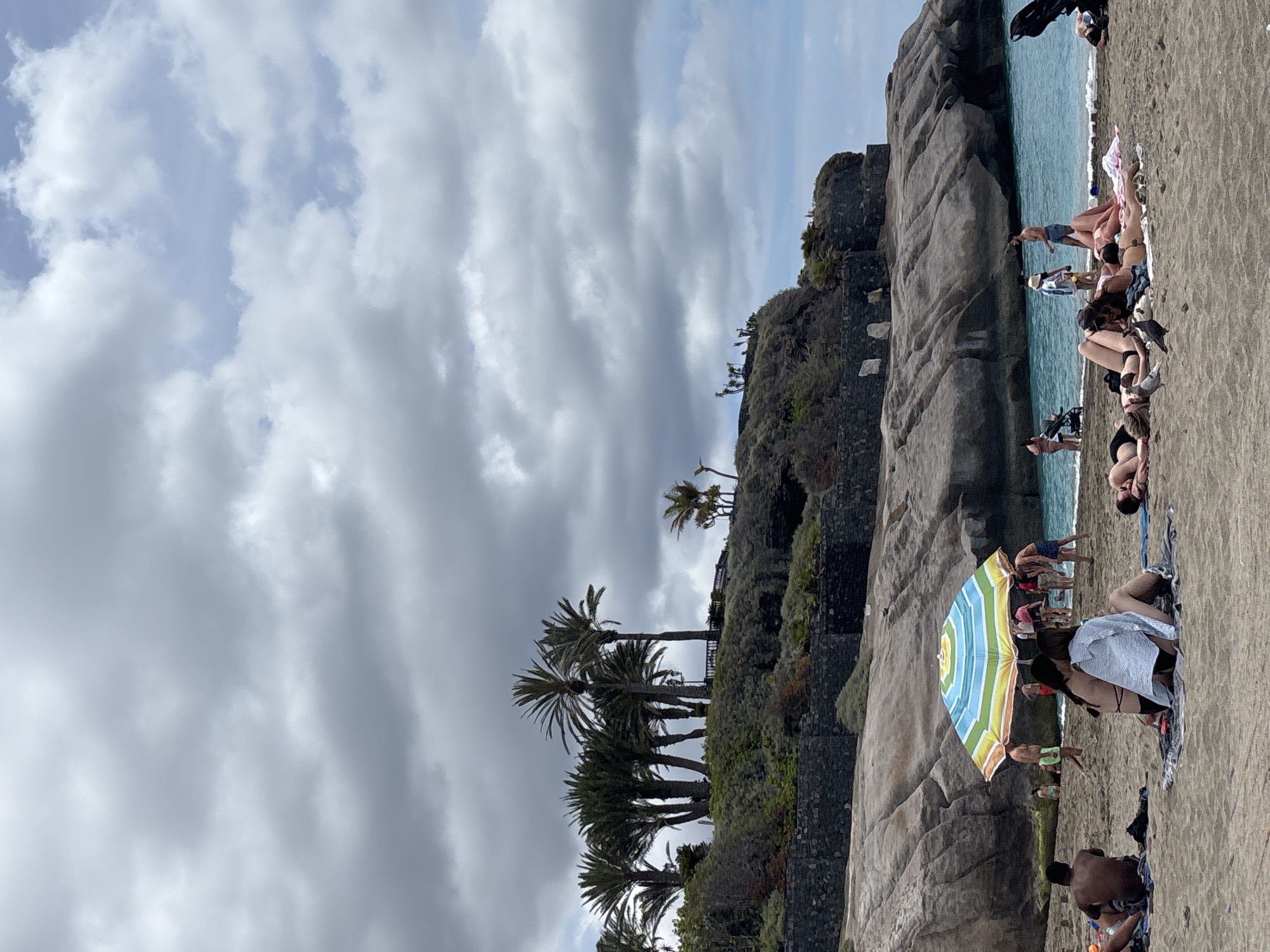 Cloudy day beach activity continues in Adeje, Spain