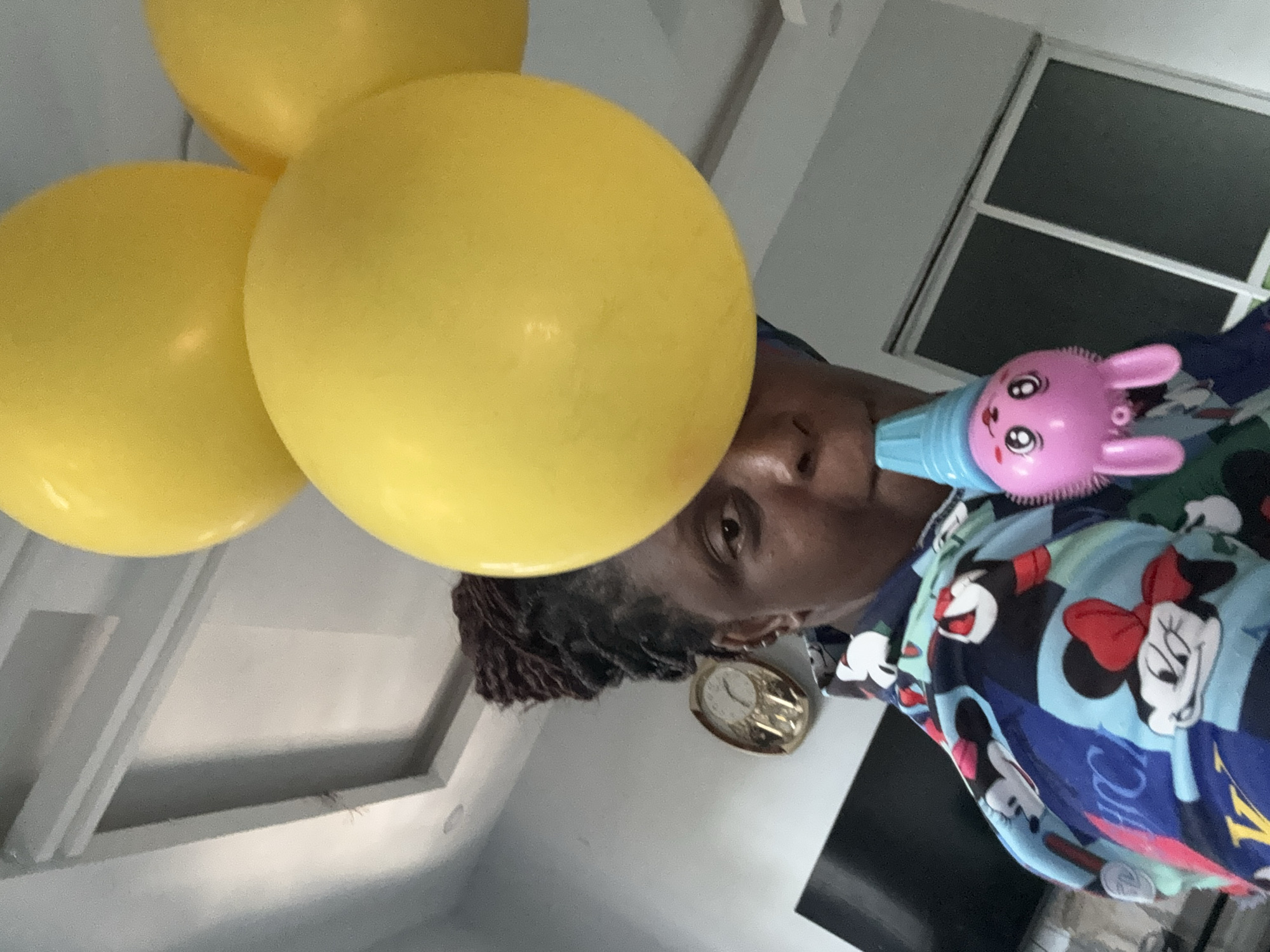 Child plays with bunny toy and balloons in Nigeria
