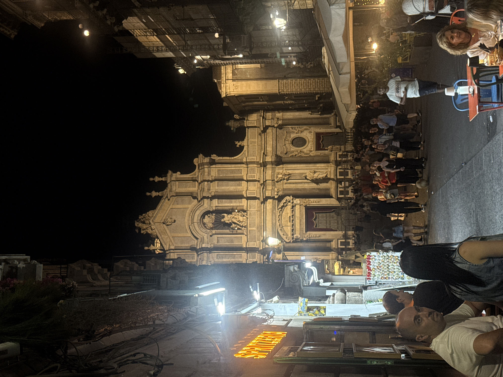 Evening street activity observed near historic Catania basilica
