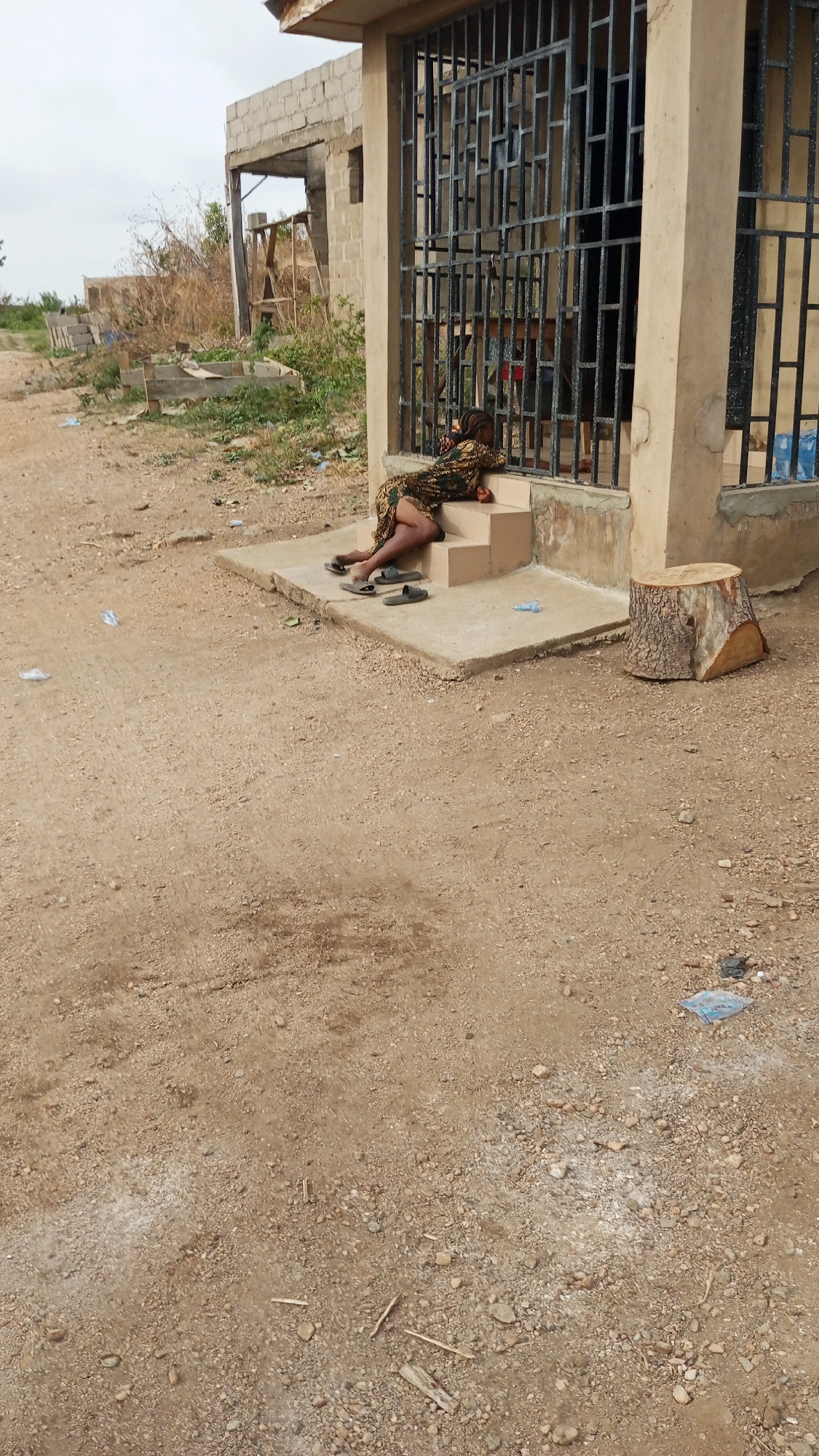 Woman rests on building steps in Zango-ndaji, Nigeria