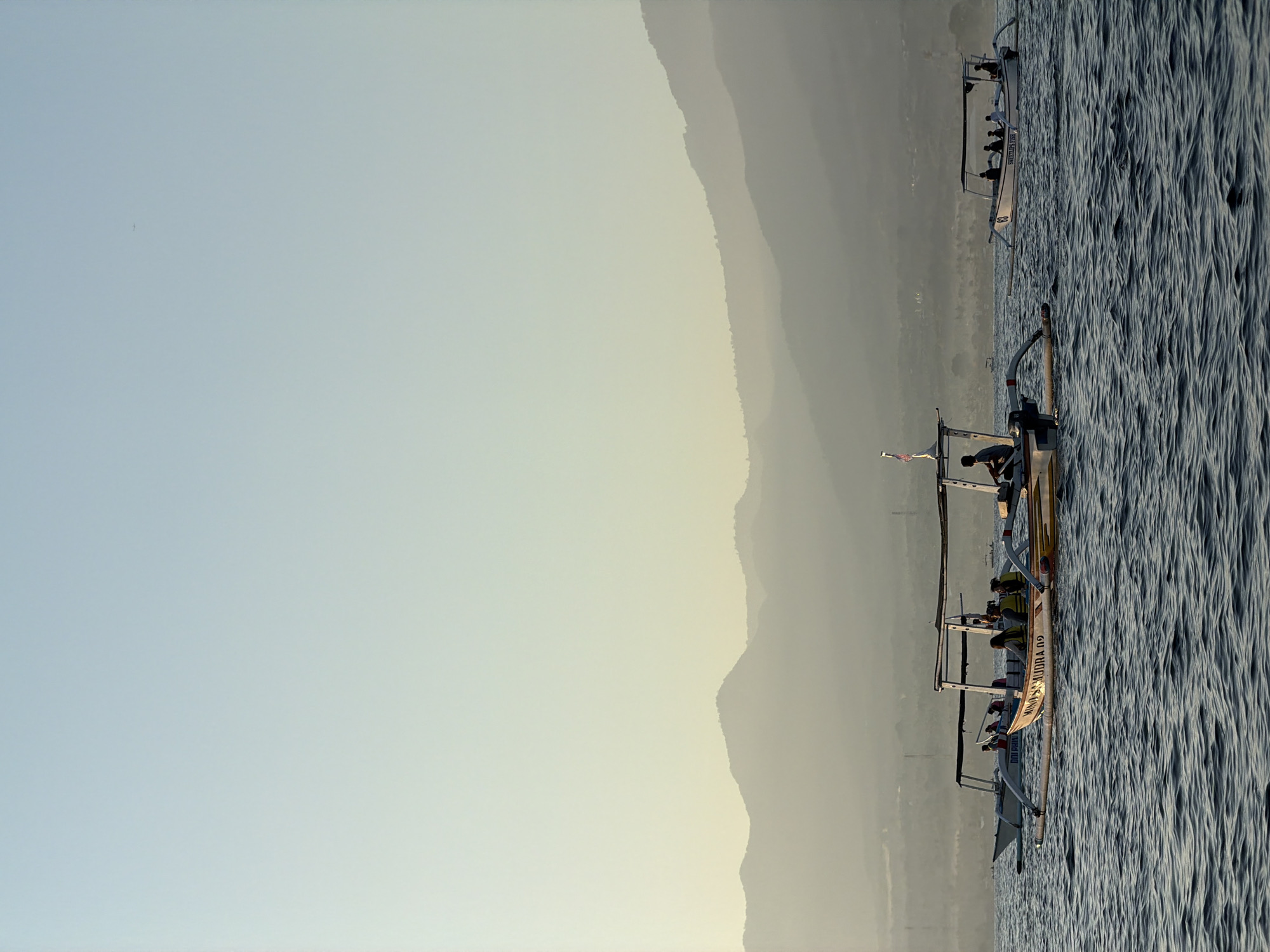 Outrigger boats crossing Buleleng waters at sunset