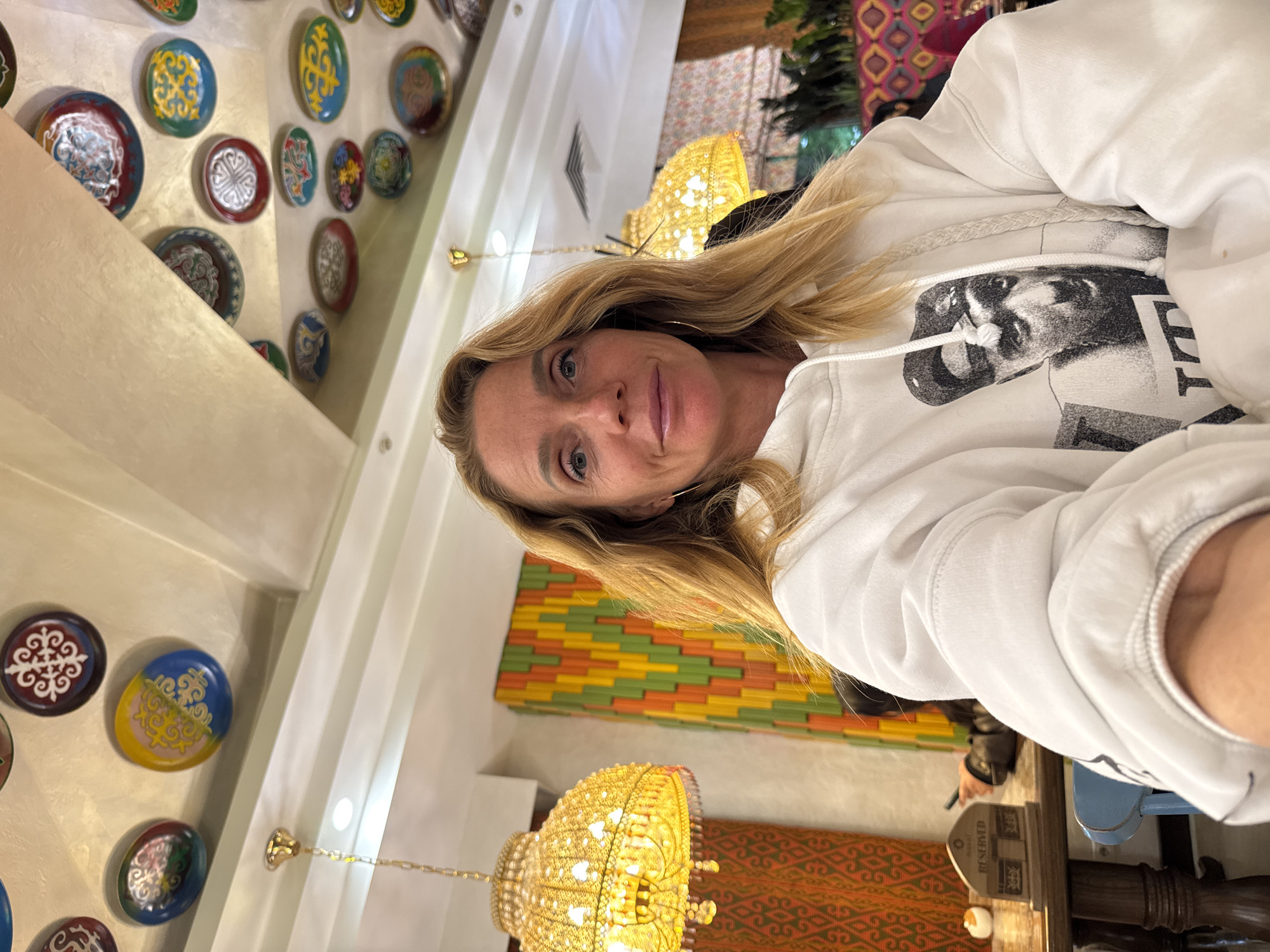 Woman takes selfies in white hoodie in Bishkek