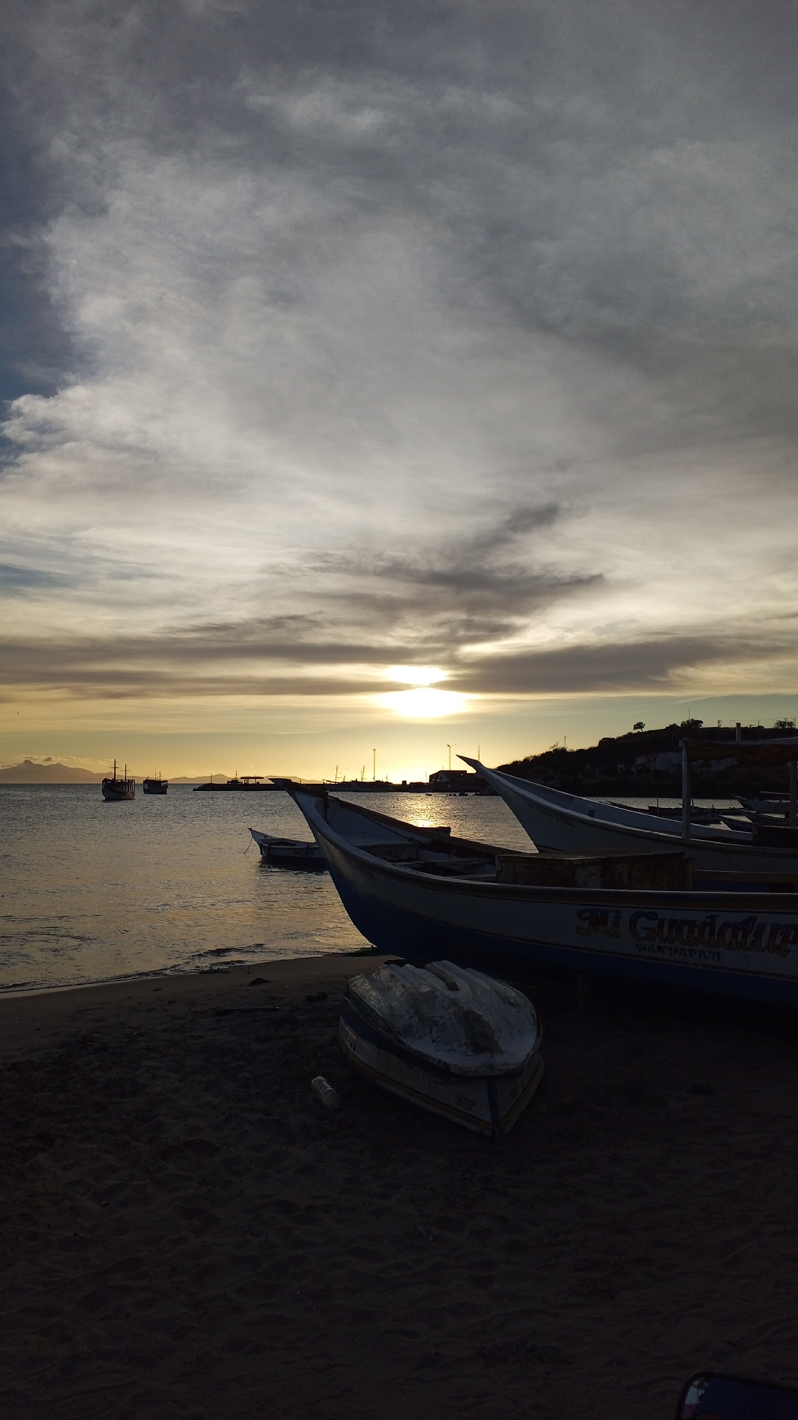 Fishing boats rest on Venezuelan beach at sunset