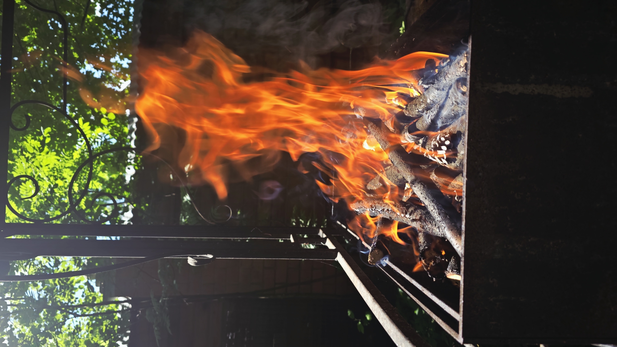 Wood-burning barbecue grill blazing in Il'inskiy backyard