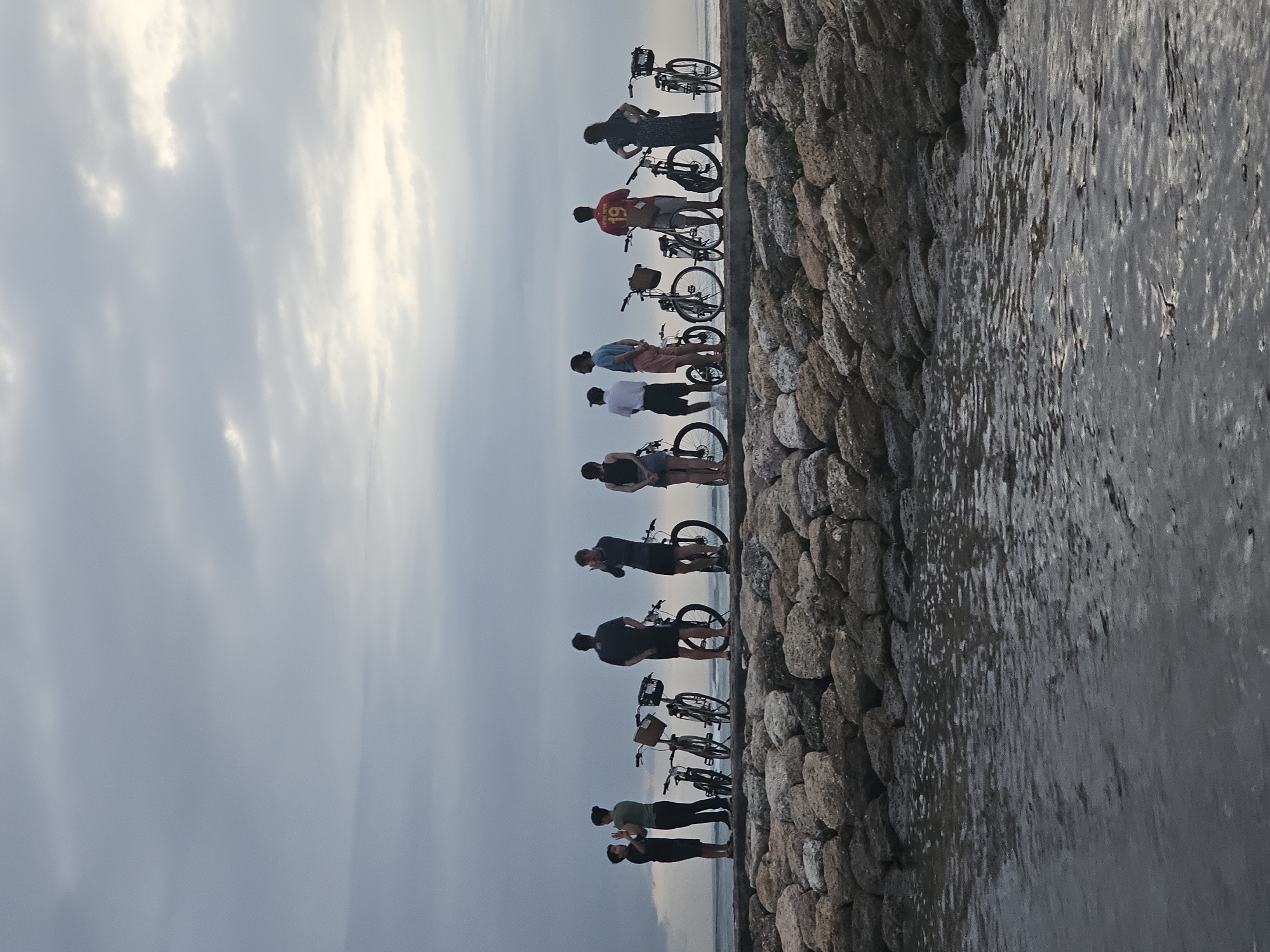 Cyclists gather at Denpasar breakwater for evening ocean viewing