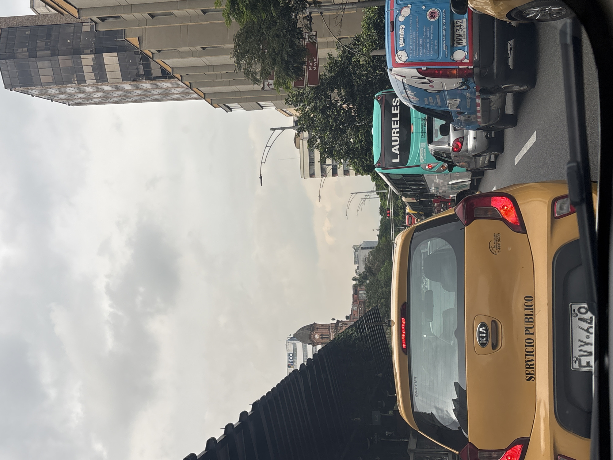 Routine traffic scene captured in Medellín with taxi and bus