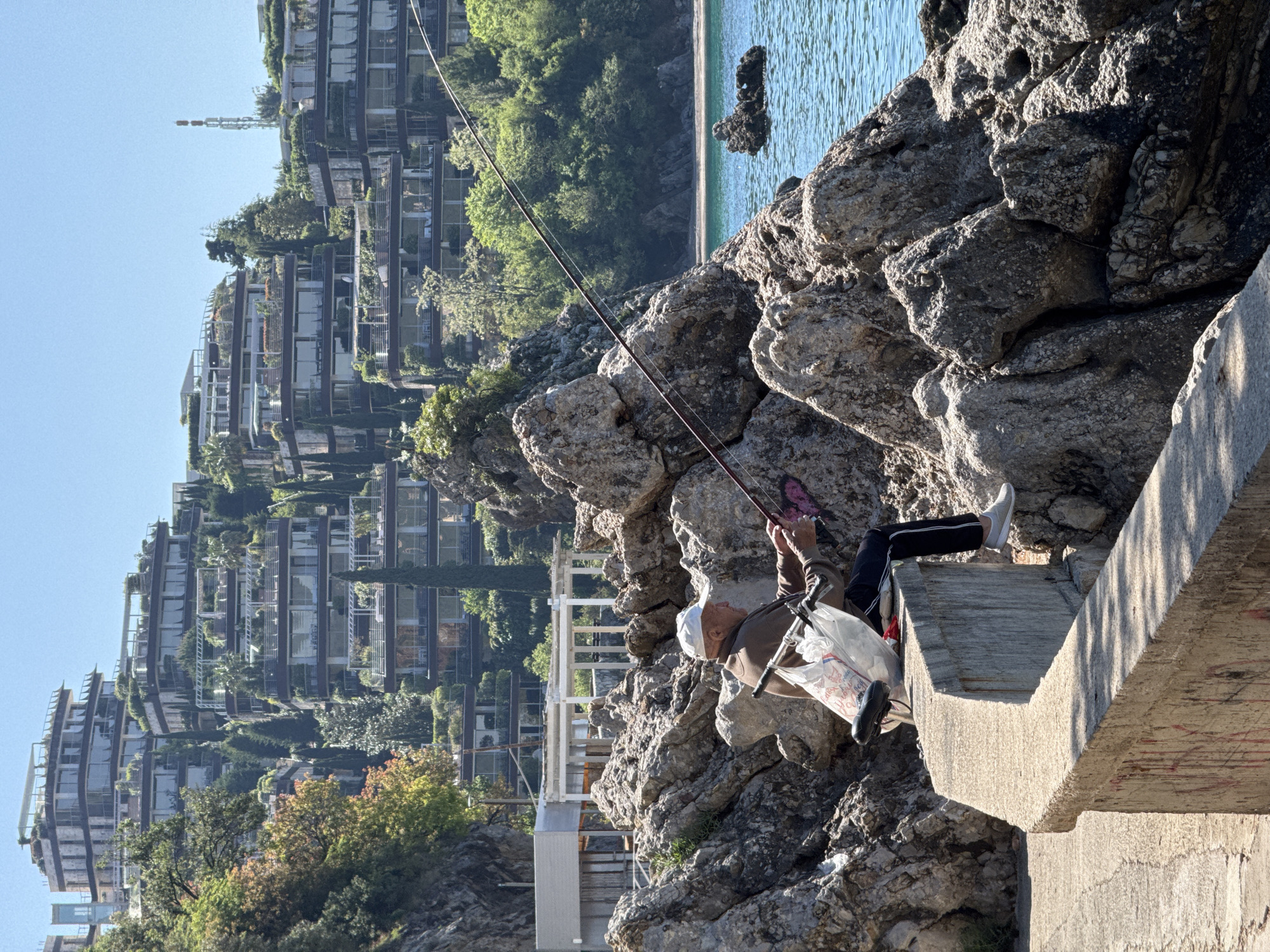 Man fishing from concrete structure in Budva, Montenegro