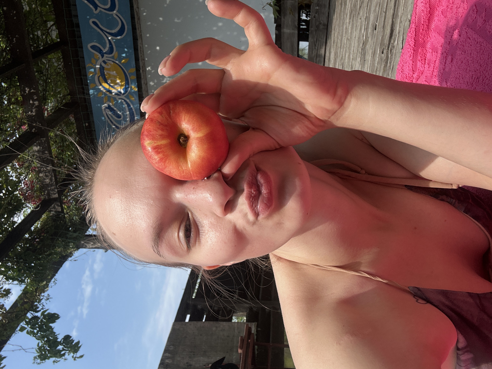 Sunny deck day in Chaikovsky: pink towel, stone fruit, waterfront vibes