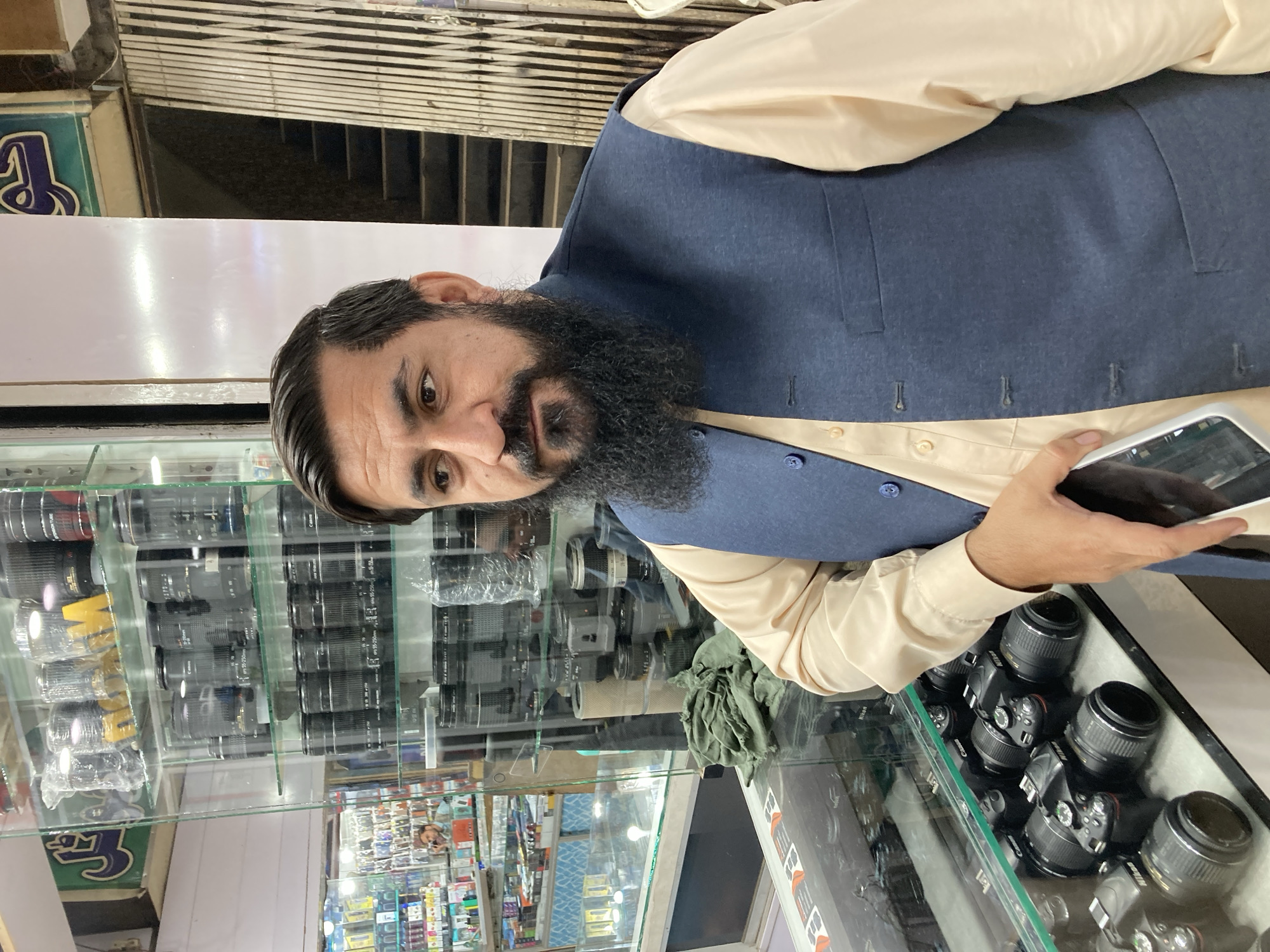 Man browsing camera equipment at electronics store in Quetta
