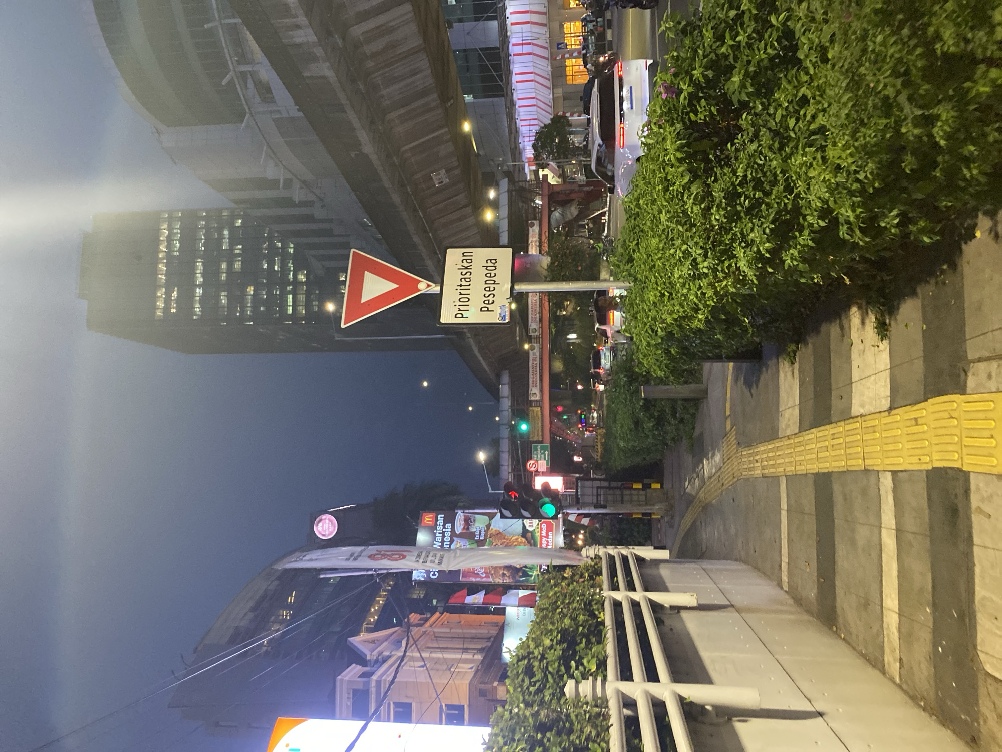 South Jakarta underpass area at dusk, foot traffic and buses