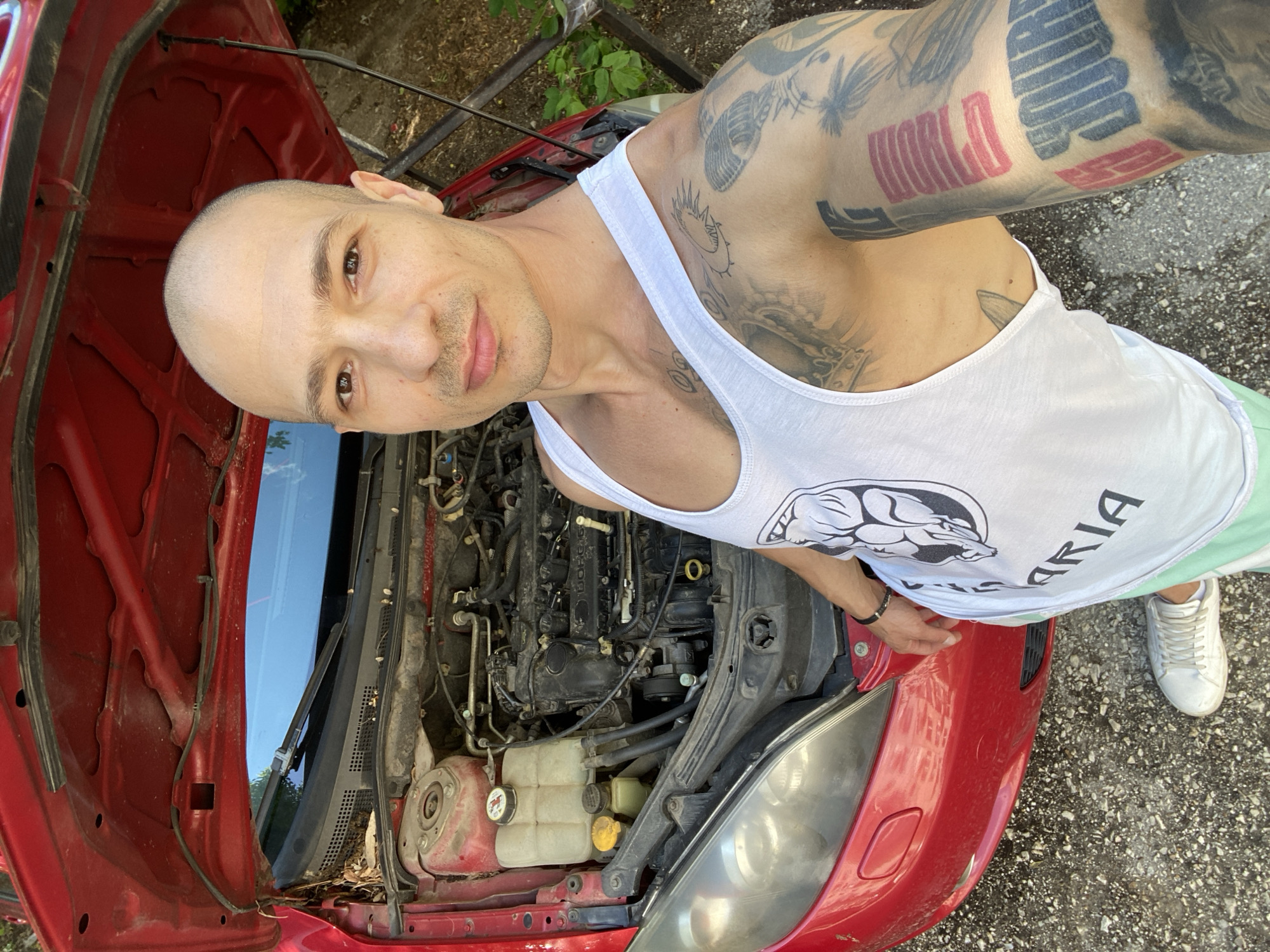 Man works on red car in Pleven, Bulgaria