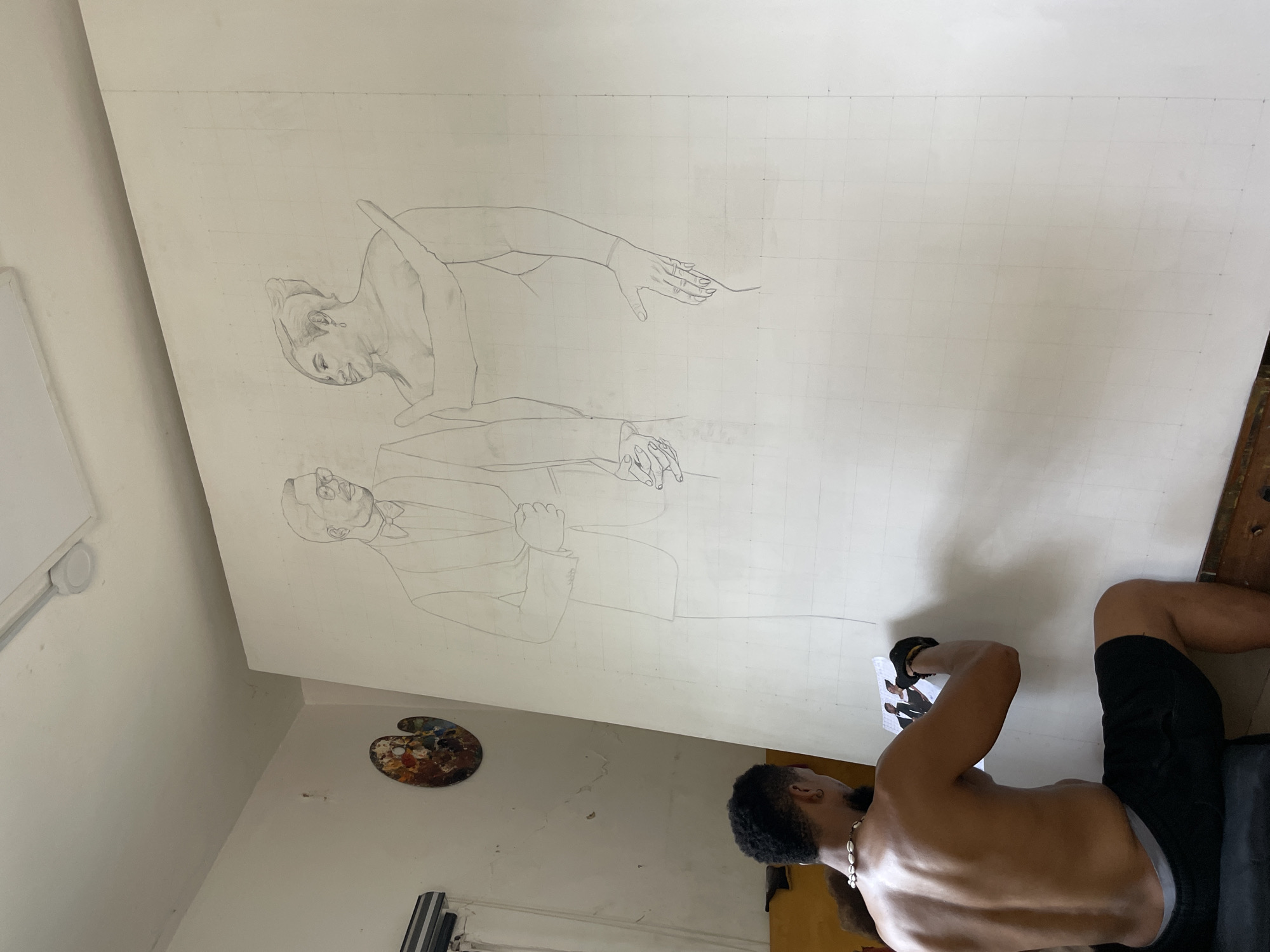 Man examines photograph beside canvas in Ado, Nigeria