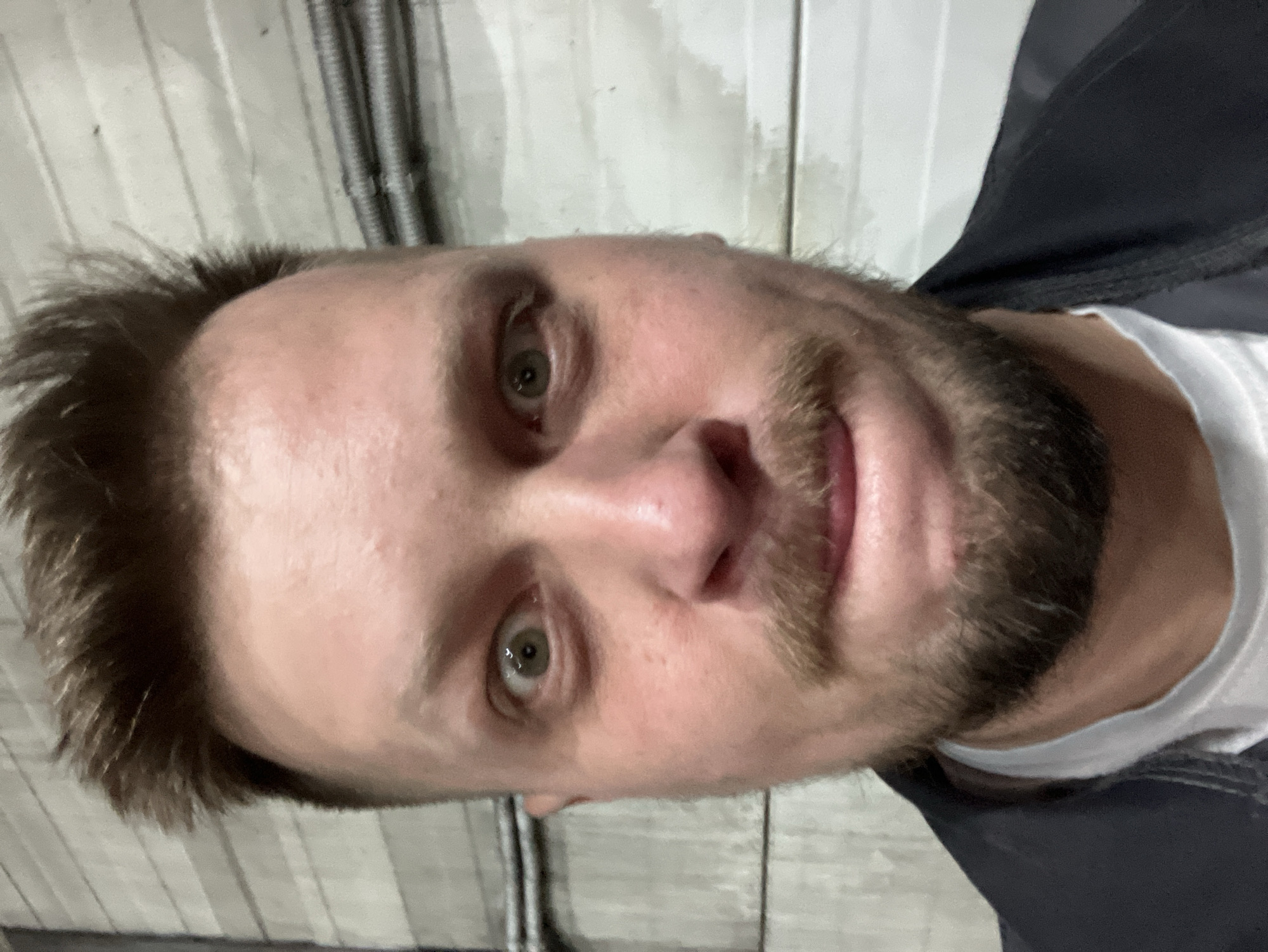 Man takes selfie against industrial wall in Noviy, Russia