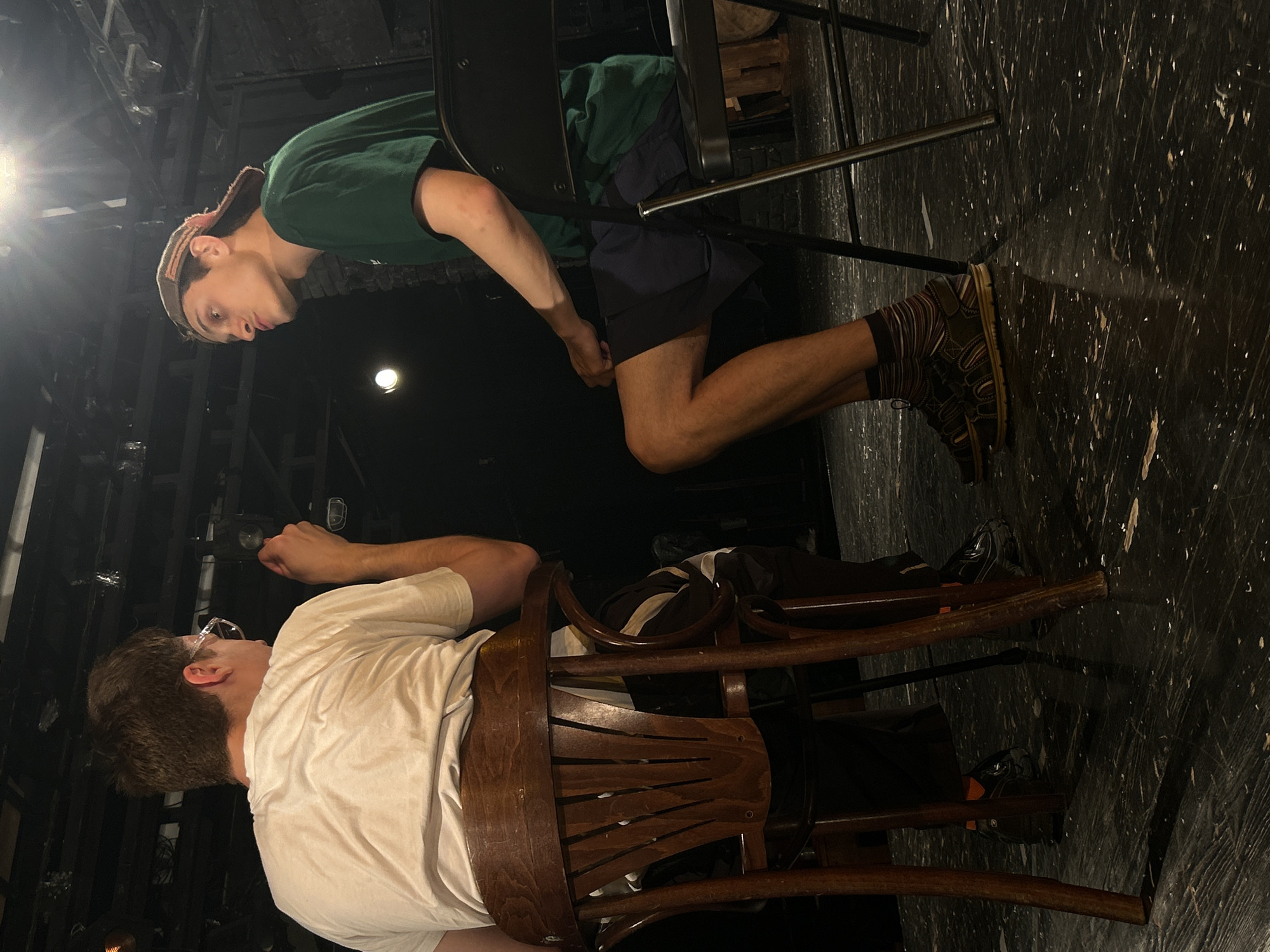Stage performance with two performers in chairs