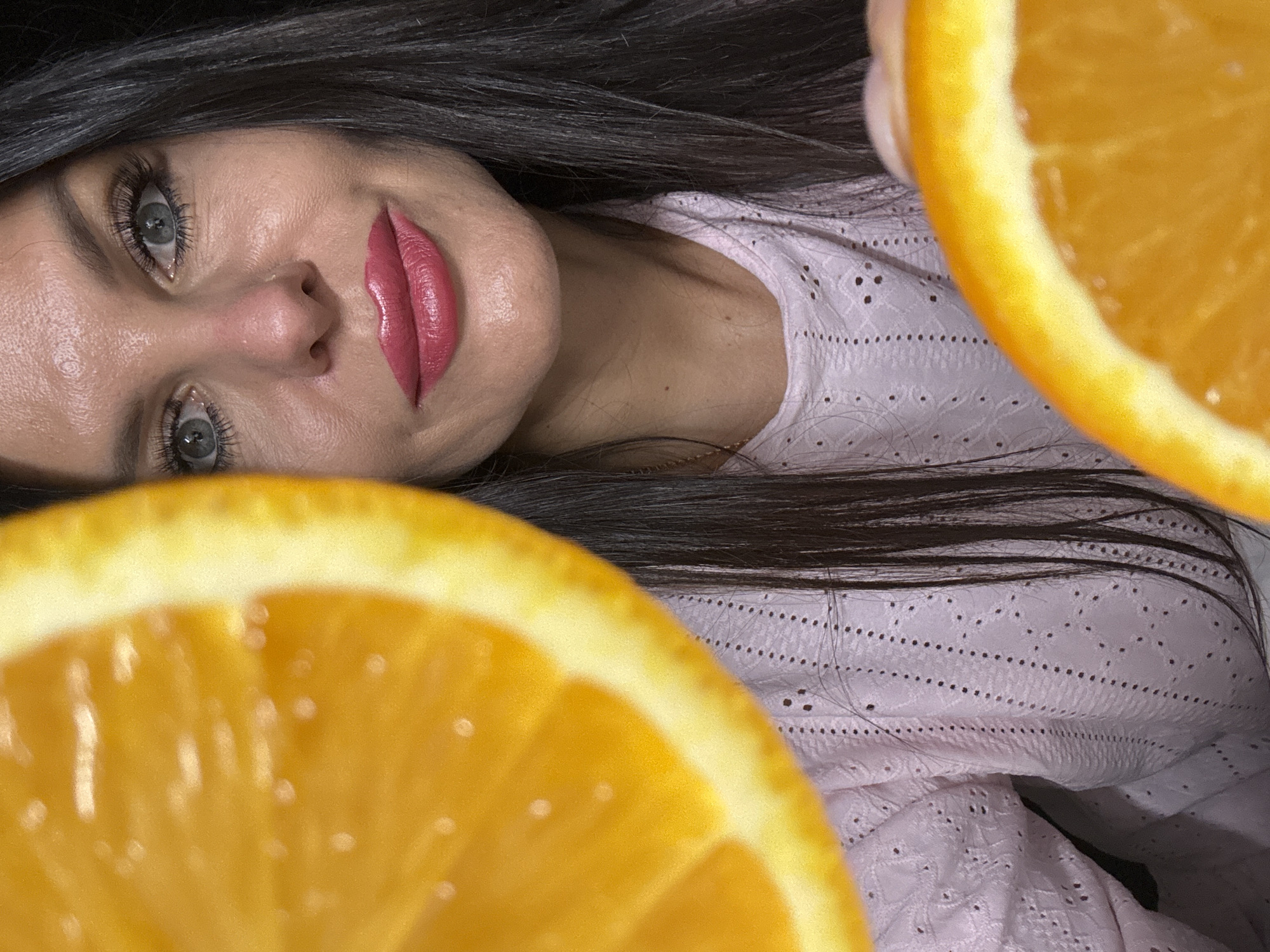 Woman poses with oranges during indoor photo session in Russia
