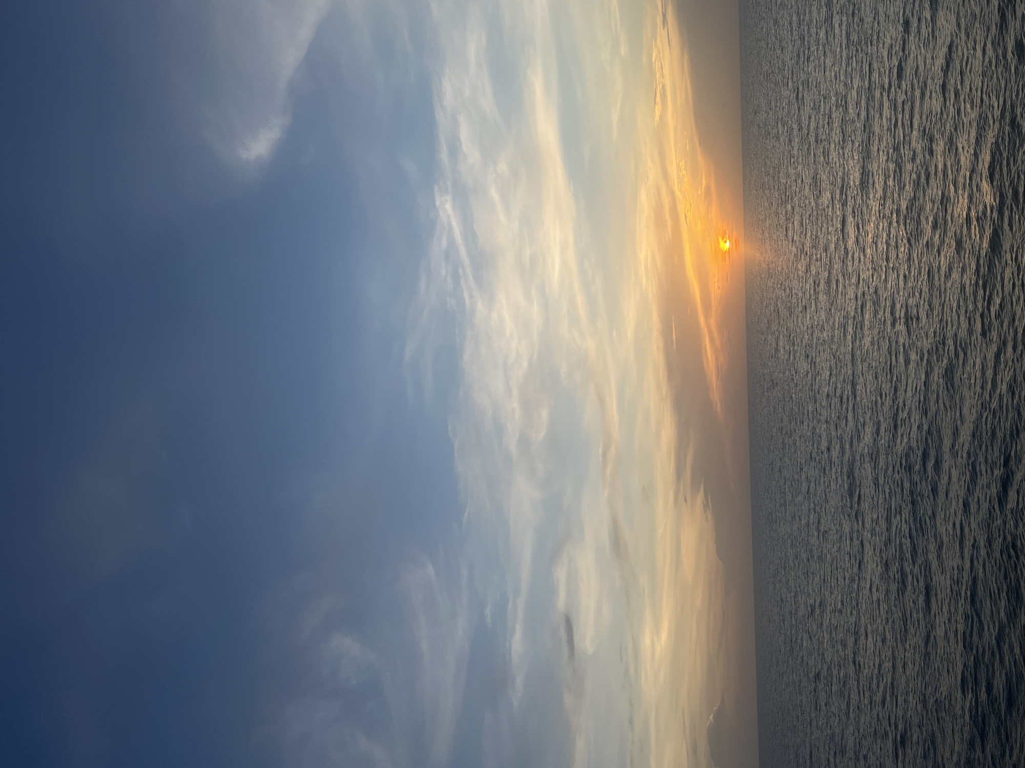 Ocean sunset observed with beverage from waterfront location