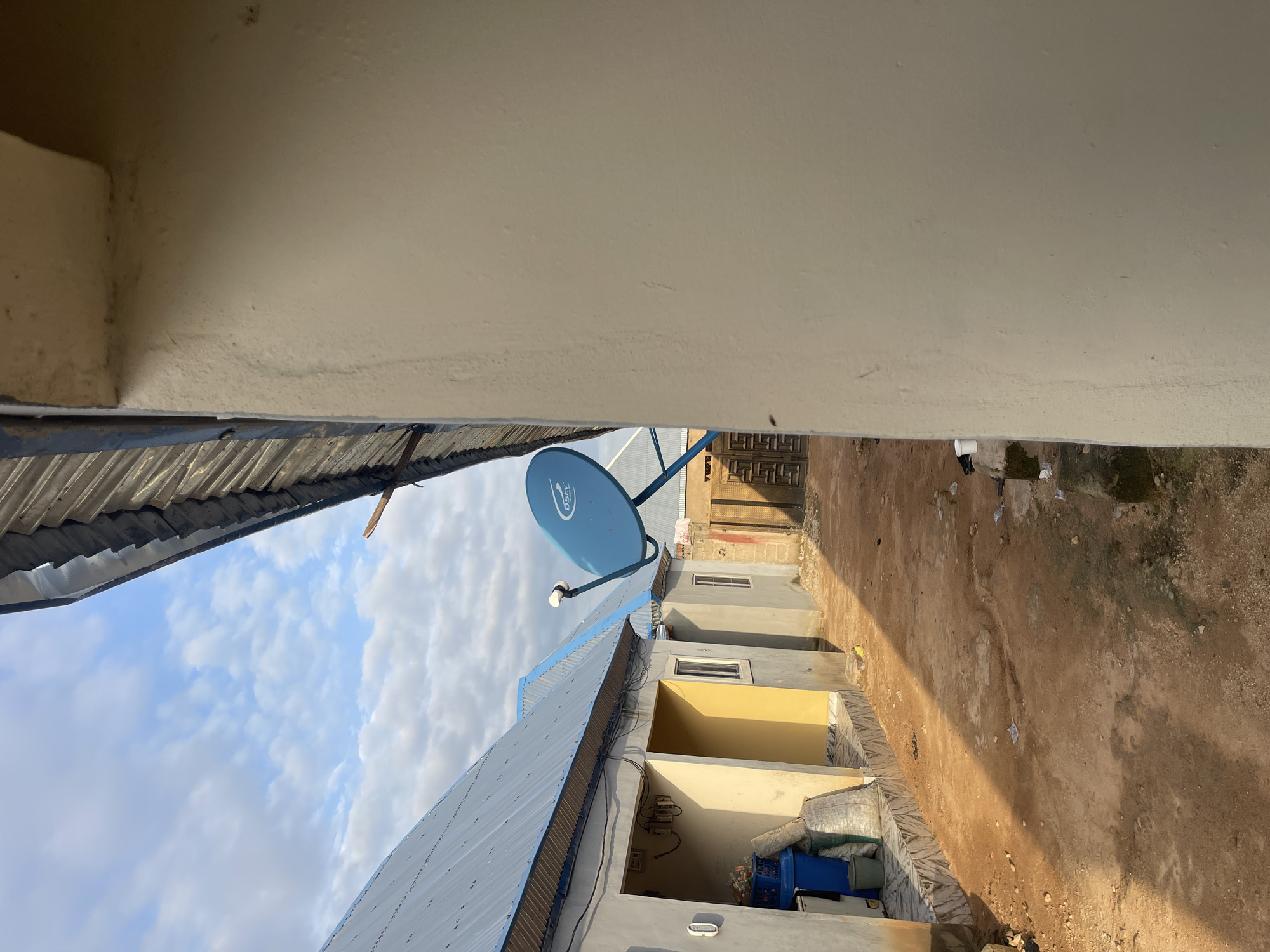 Early morning inside and outside a Nigerian compound, lit in blue