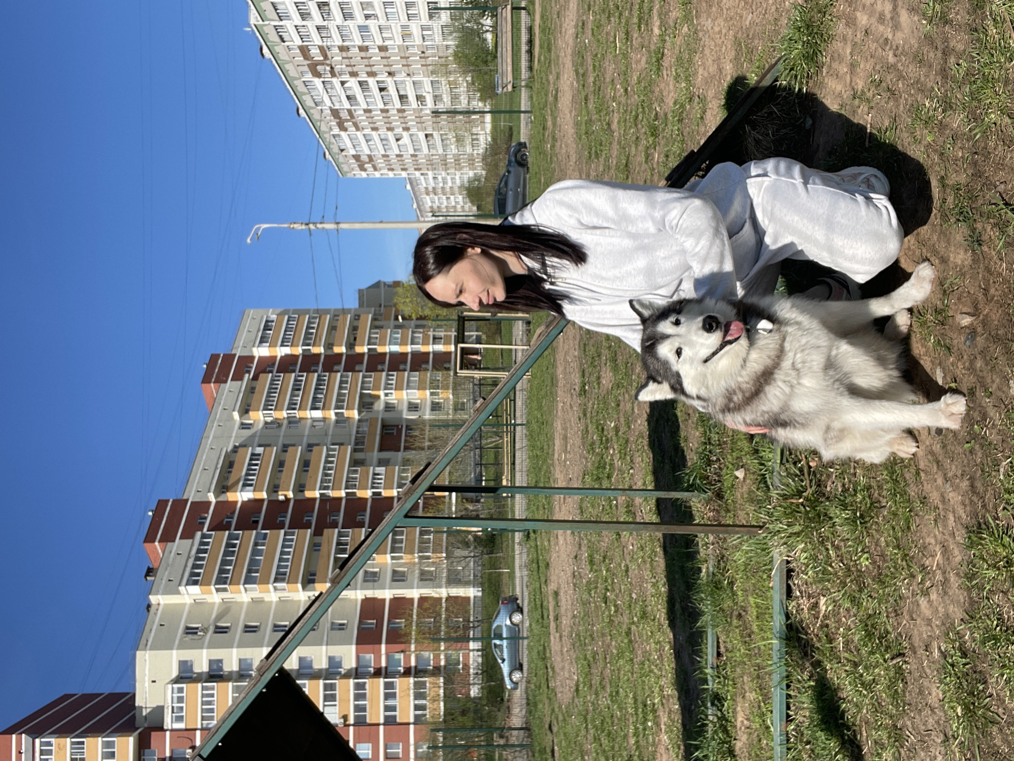 Woman pets husky in park in Светлое, Russia