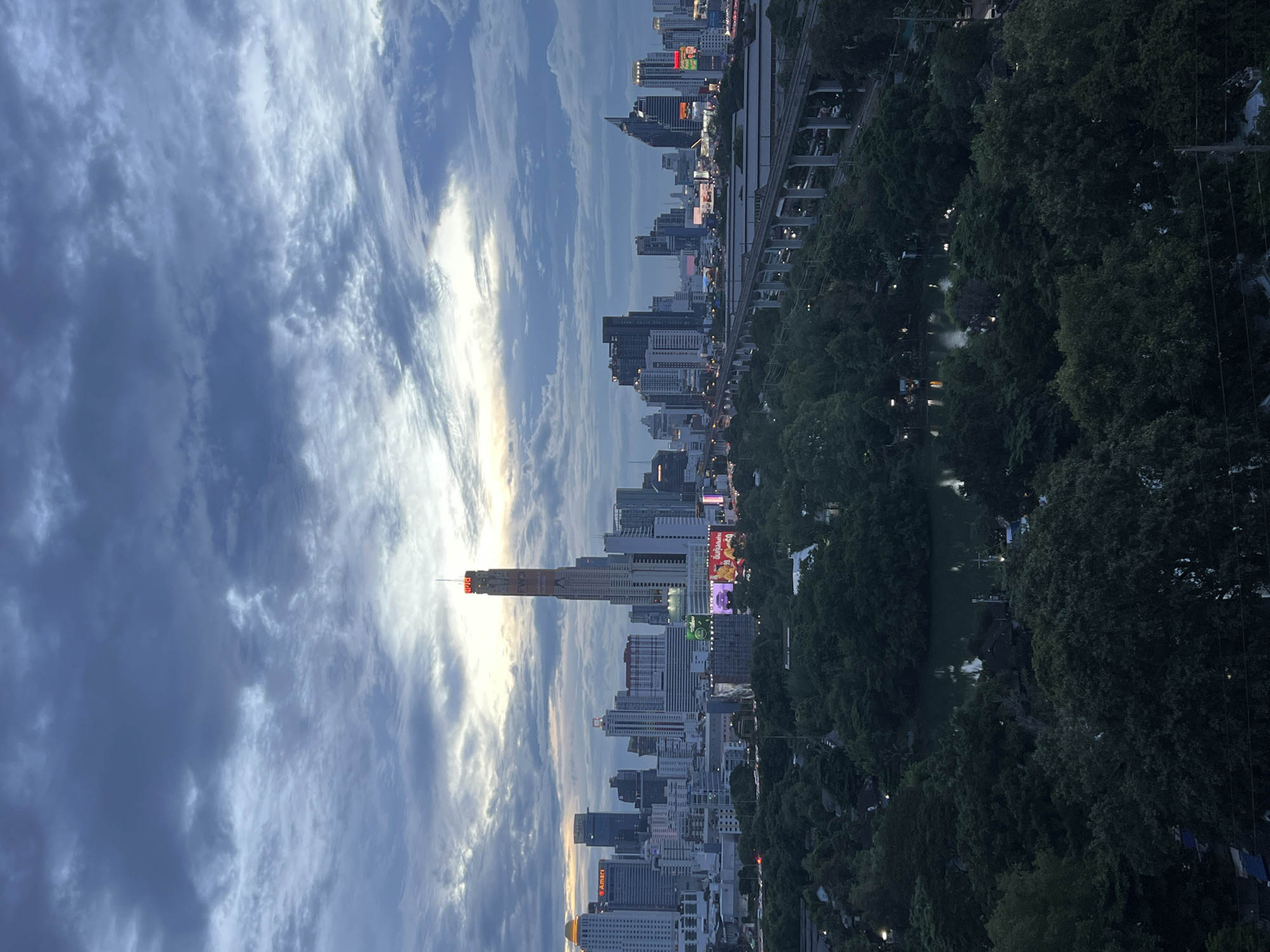 Bangkok skyline silhouetted against a moody dusk sky