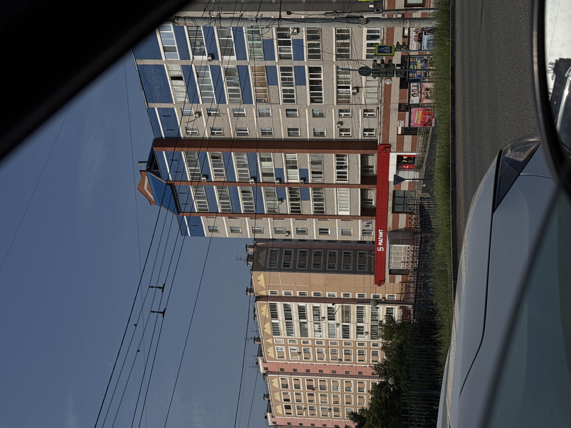 Sunny afternoon traffic and architecture along an Izhevsk main road