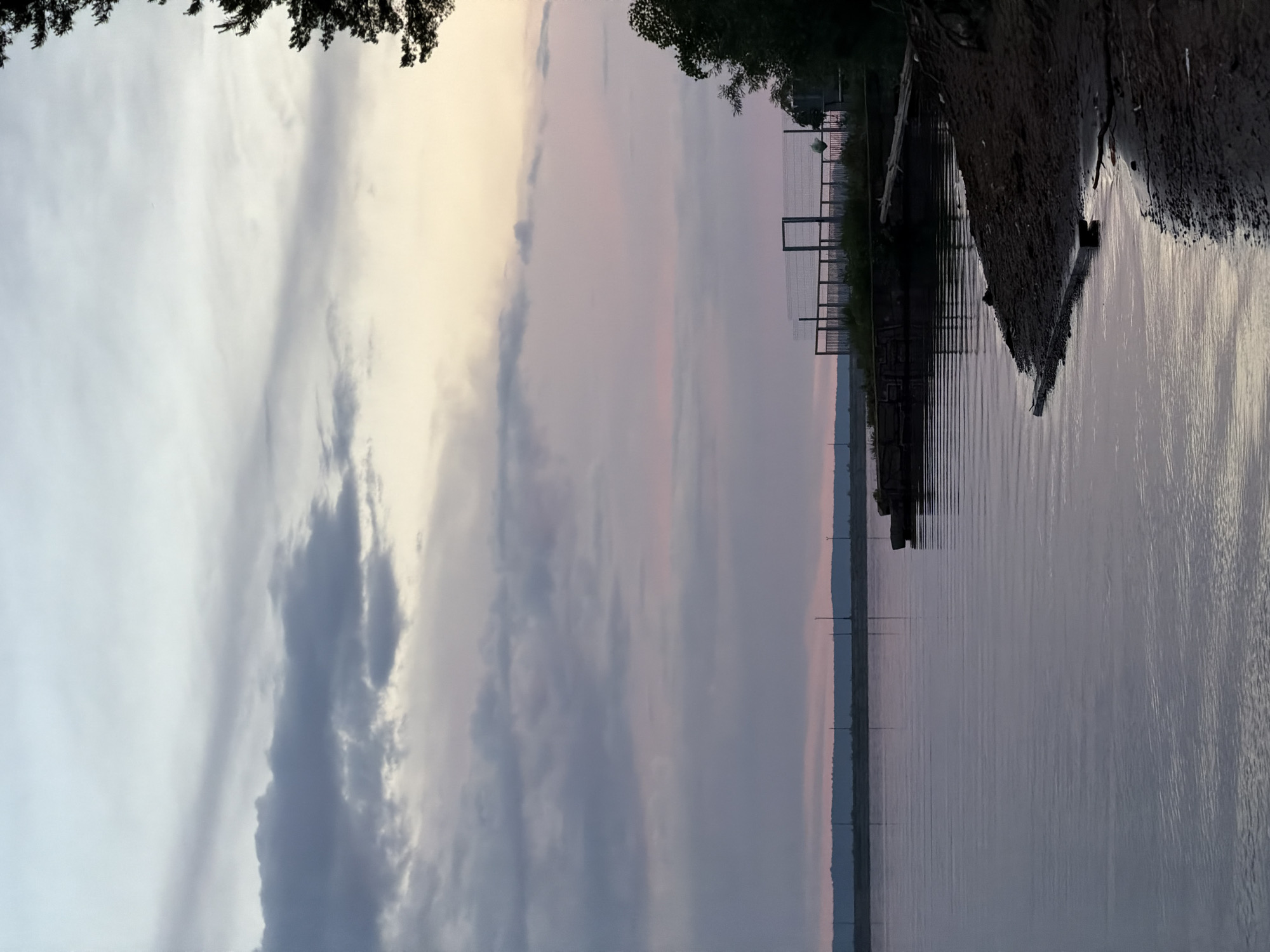 Cruise ships dock on Kama River as locals fish, photograph