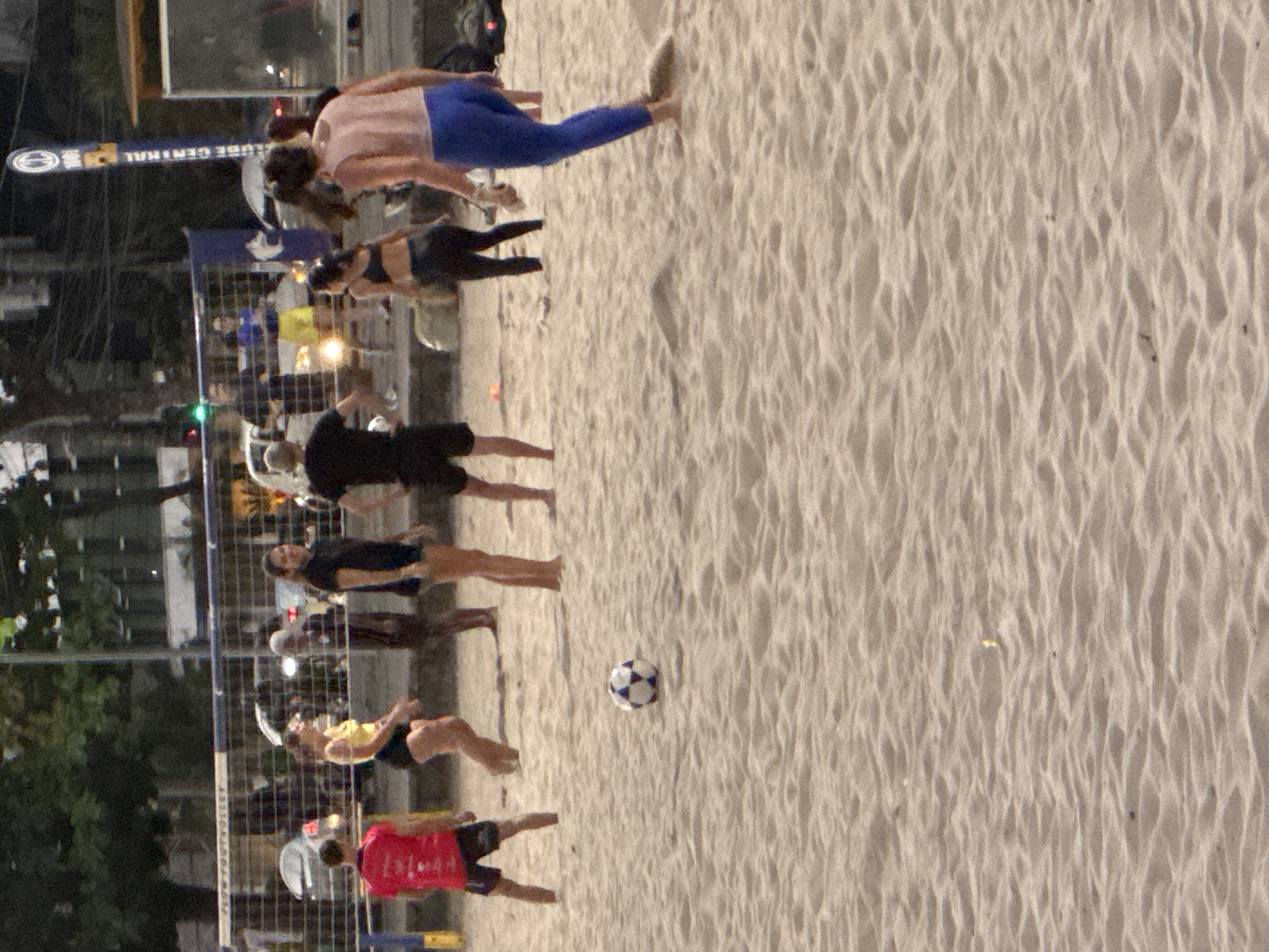 Evening beach life in Niterói — soccer, jogging, and city backdrop