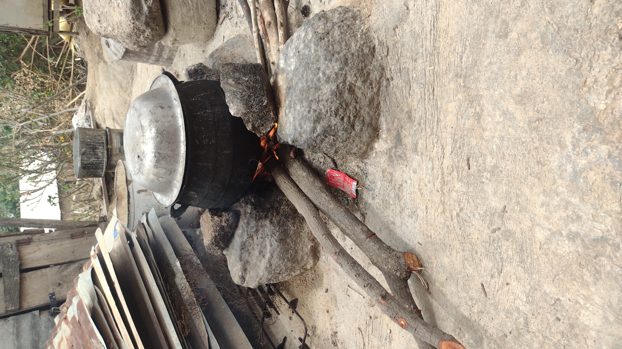 Man conducts outdoor cooking with wheelbarrow in Jos, Nigeria