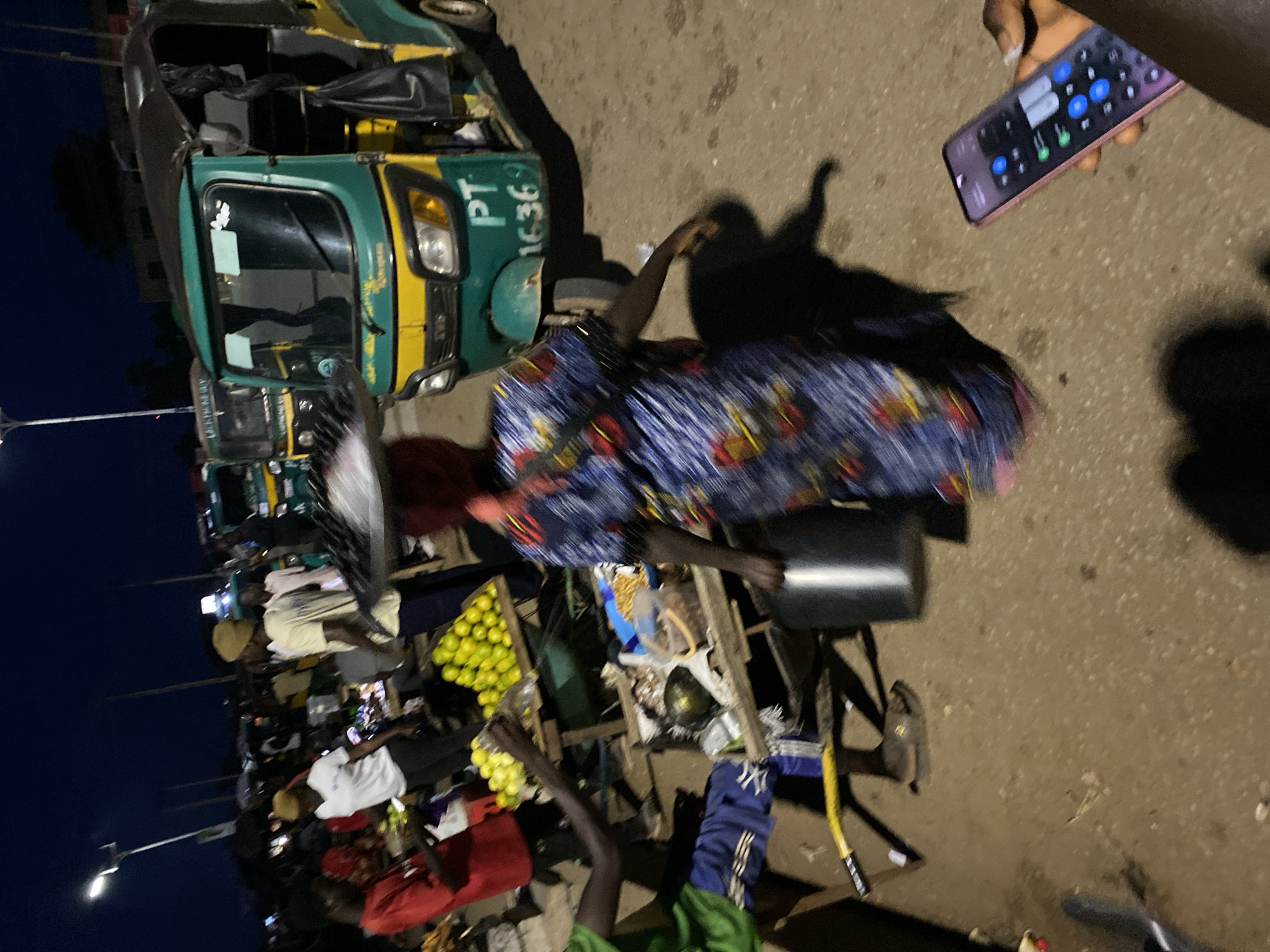 Bukuru street life at dusk: markets, traffic, and loaded vehicles