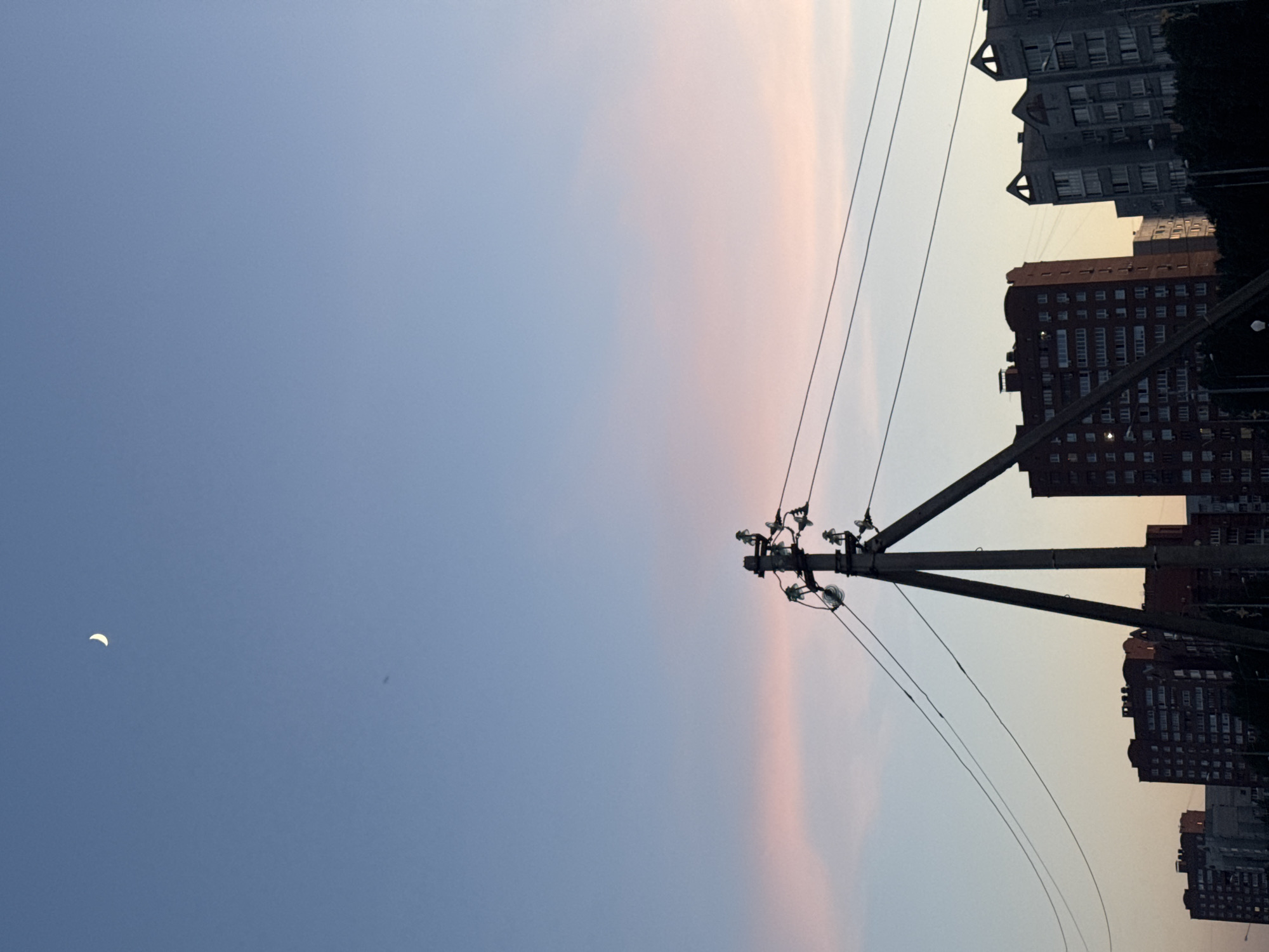 Urban dusk captured by witnesses showing crescent moon, cityscape