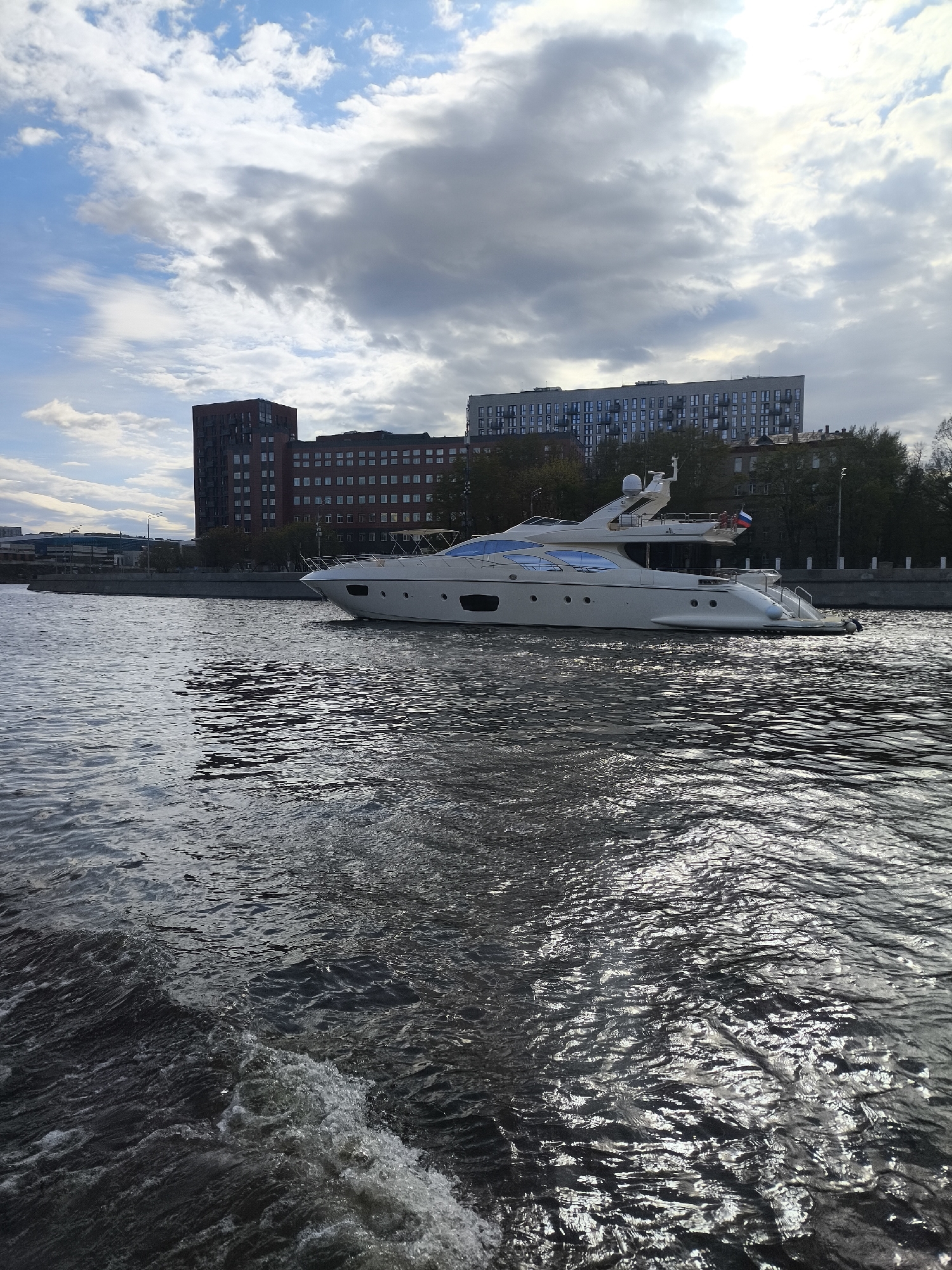 White yacht sails Moscow River past city landmarks