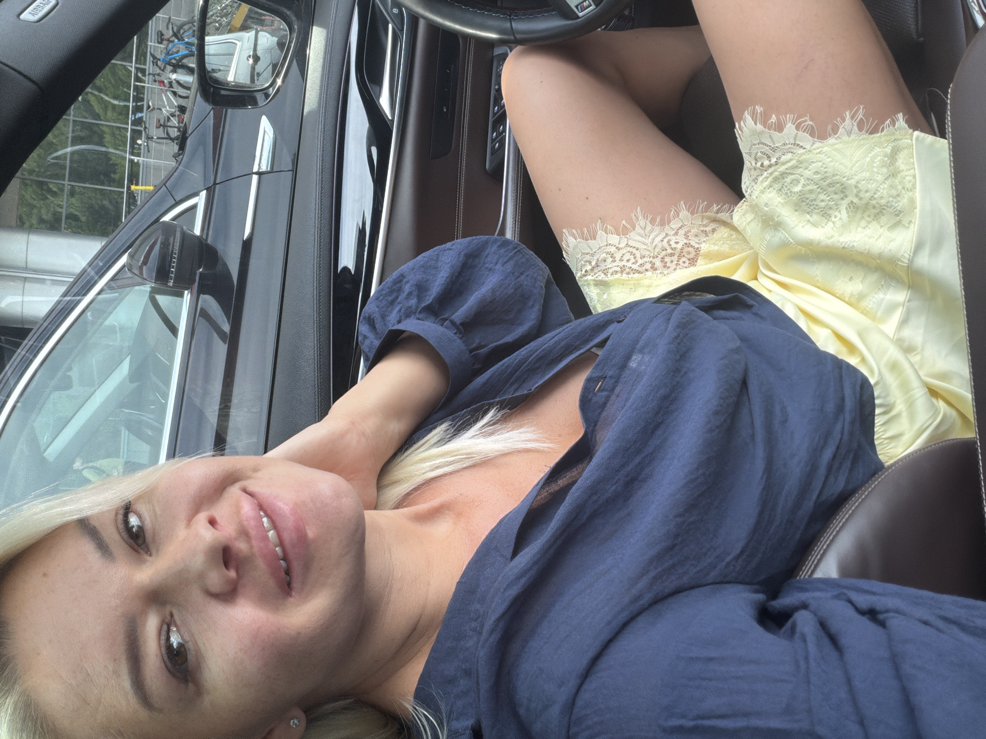 Smiling from the driver's seat of a parked car