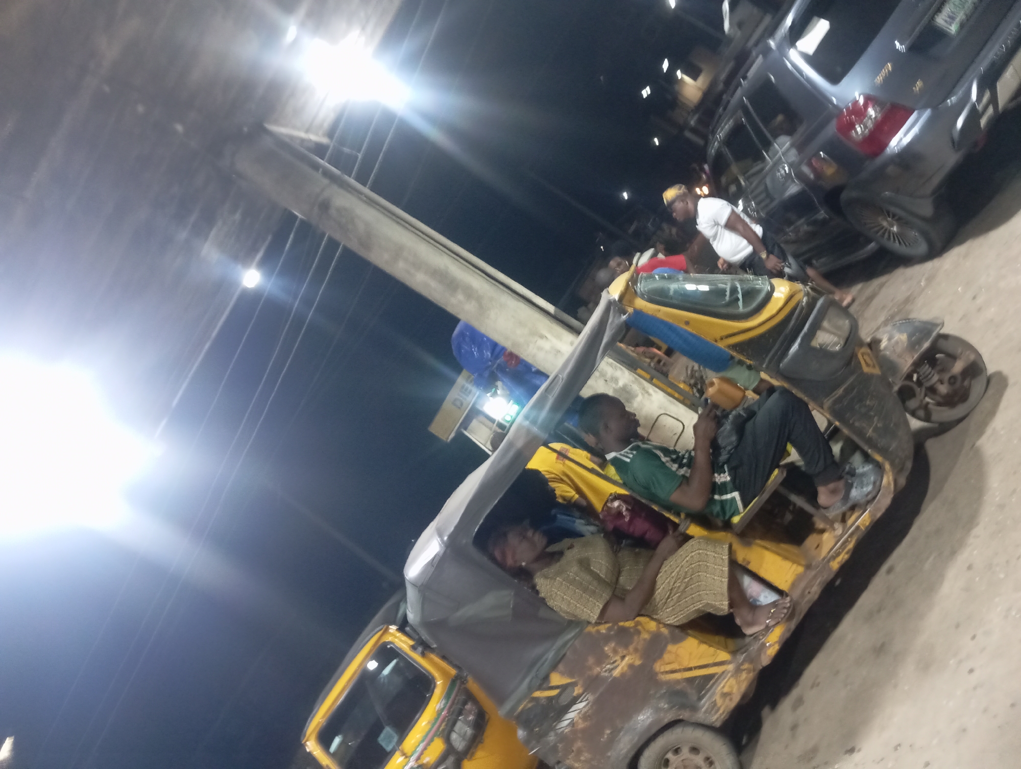 Night scene shows Keke Napep and SUV in Nkpor