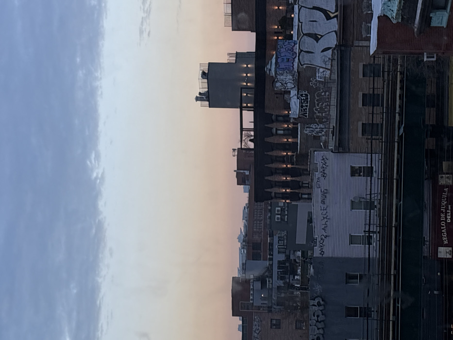 NYC skyline observed under gradient blue-orange evening sky