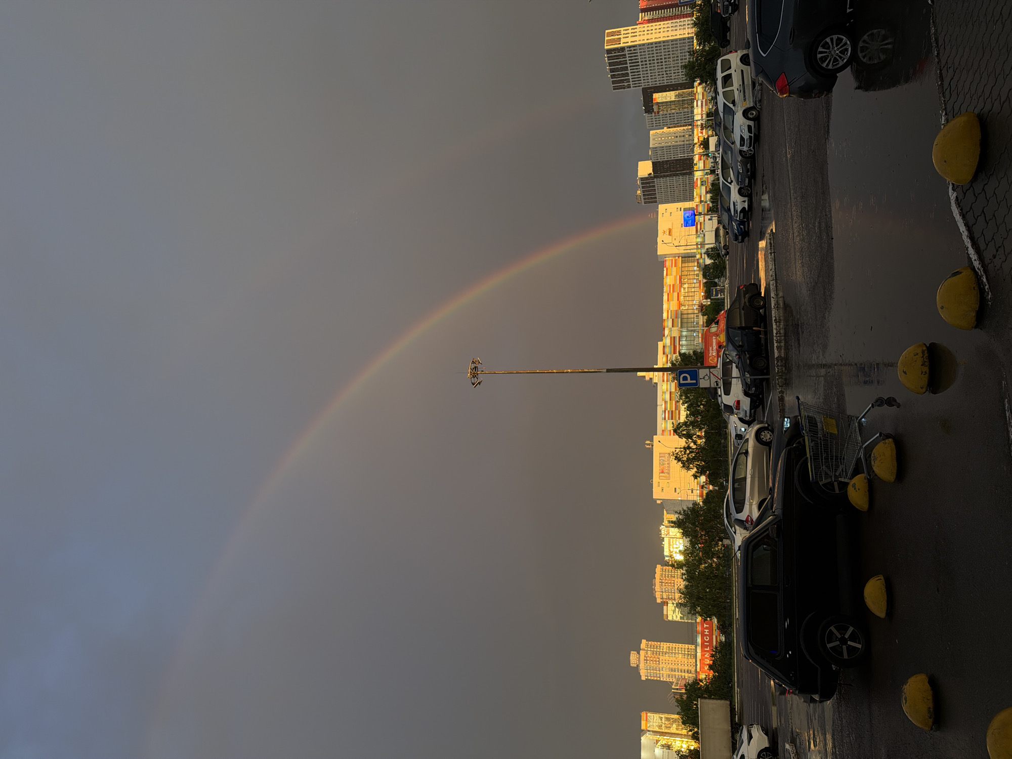 Double rainbow over a rainy Krasnoyarsk parking lot
