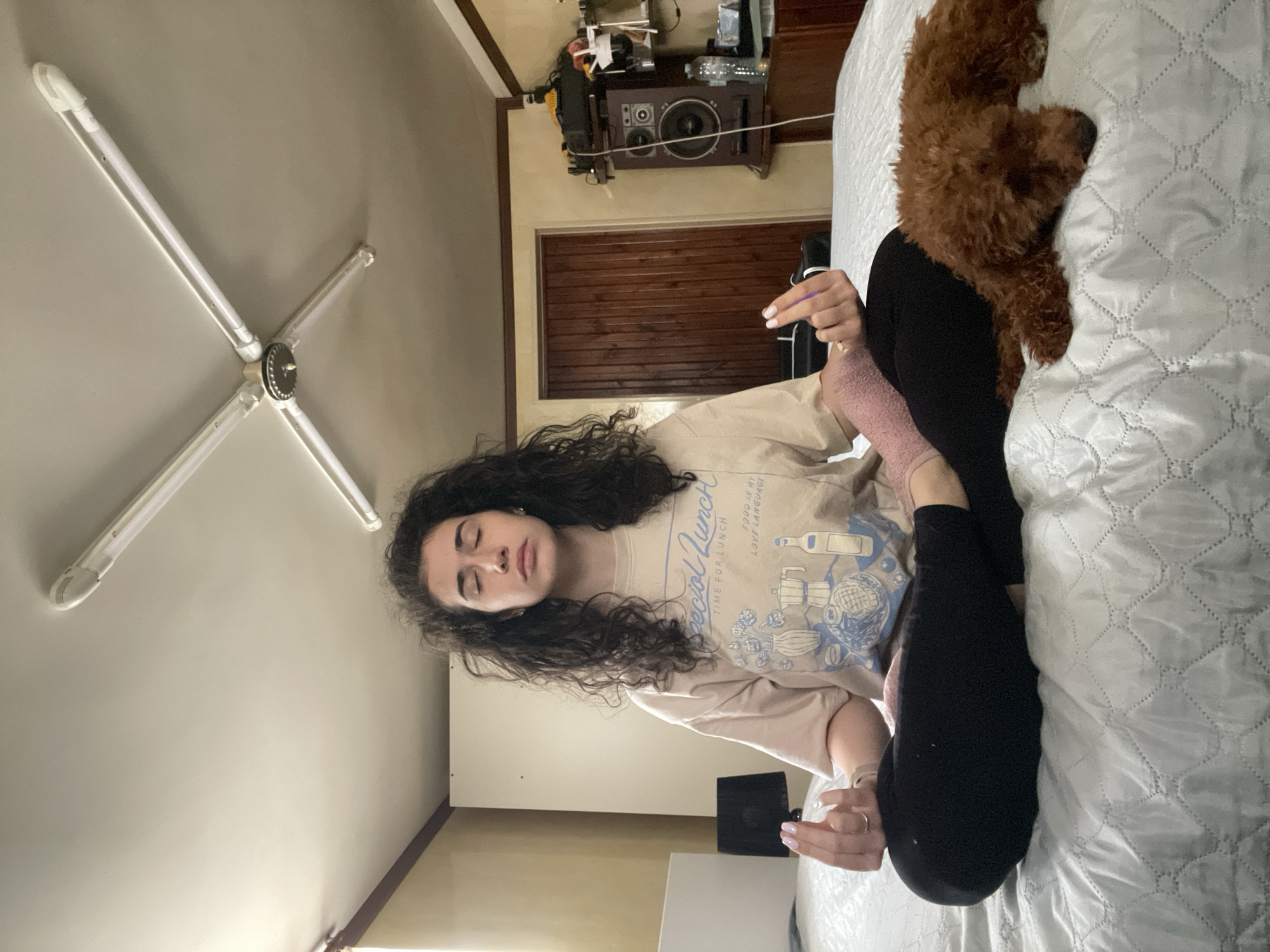 Woman enjoys Sunday morning yoga and reading with poodle