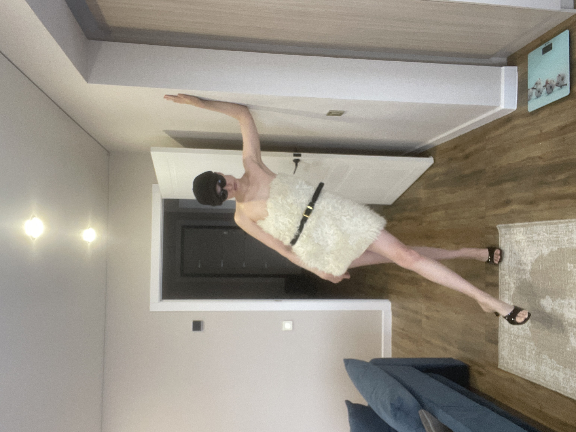 Masked figure in white garment spotted against wall