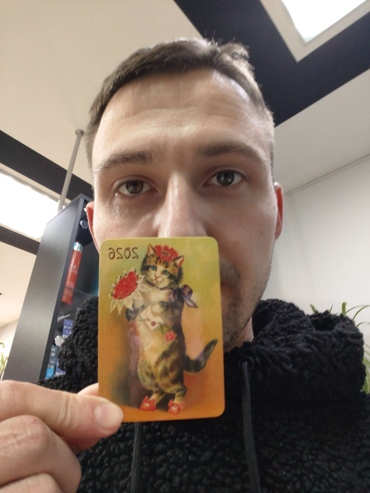 Man displays card with floral crown cat artwork