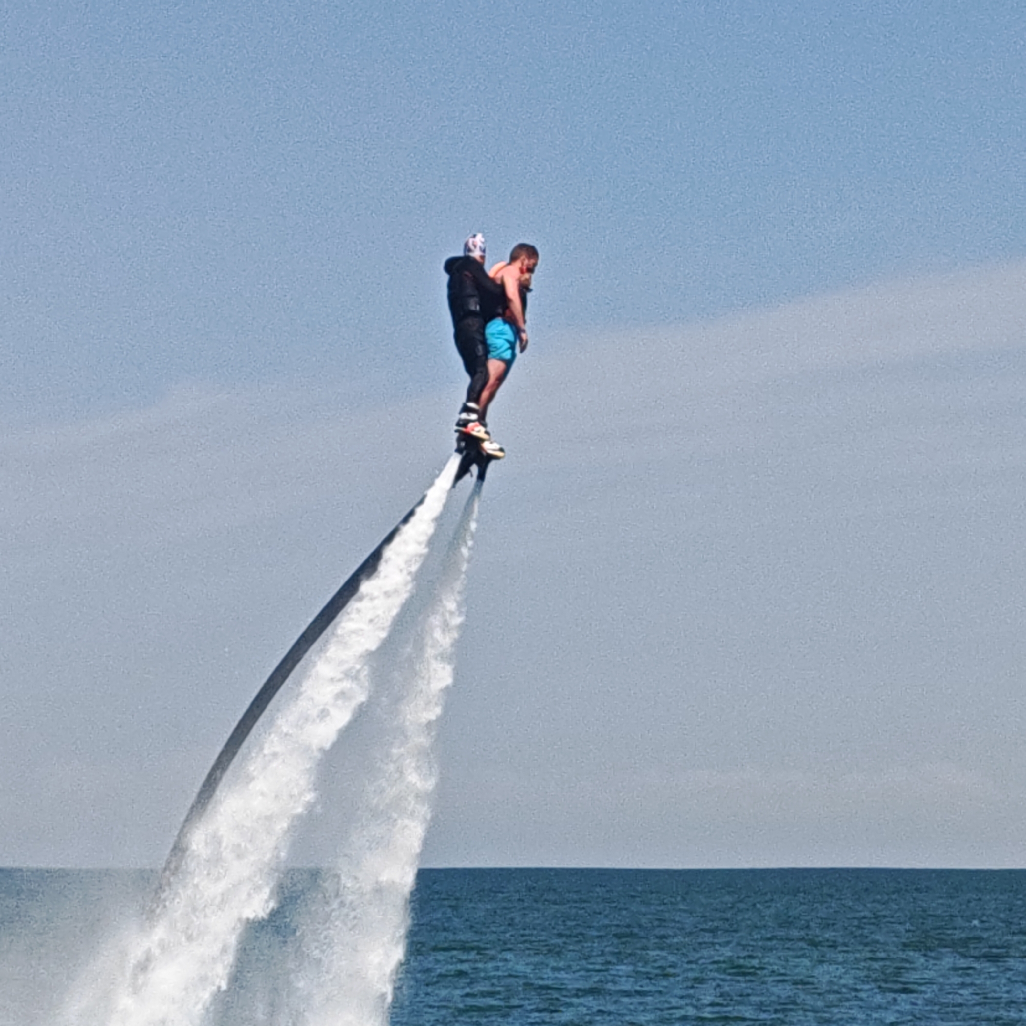 Beach resort bustling with water sports, crowds under sunny skies
