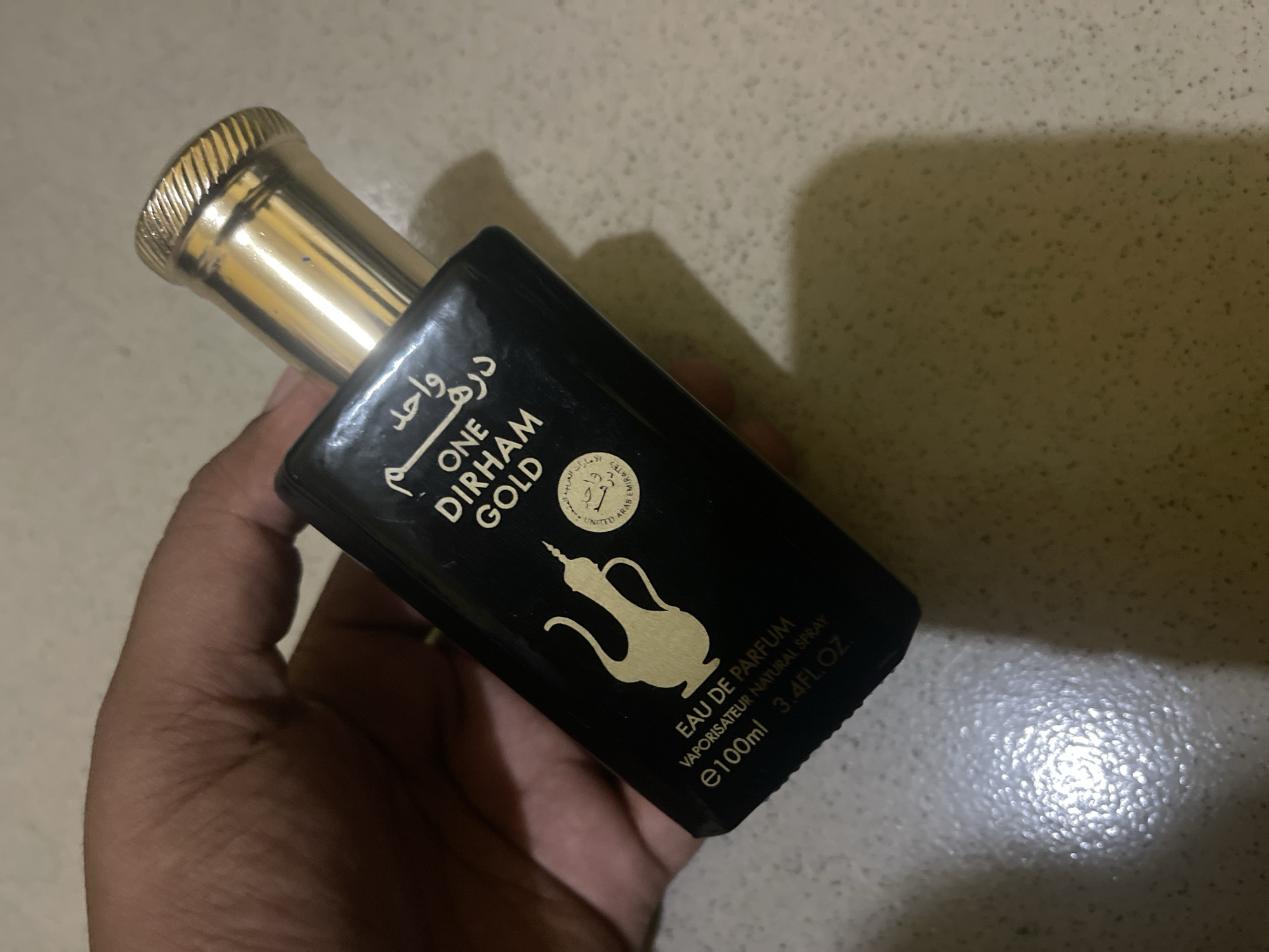Person examines Arabic perfume bottle in Dar es Salaam