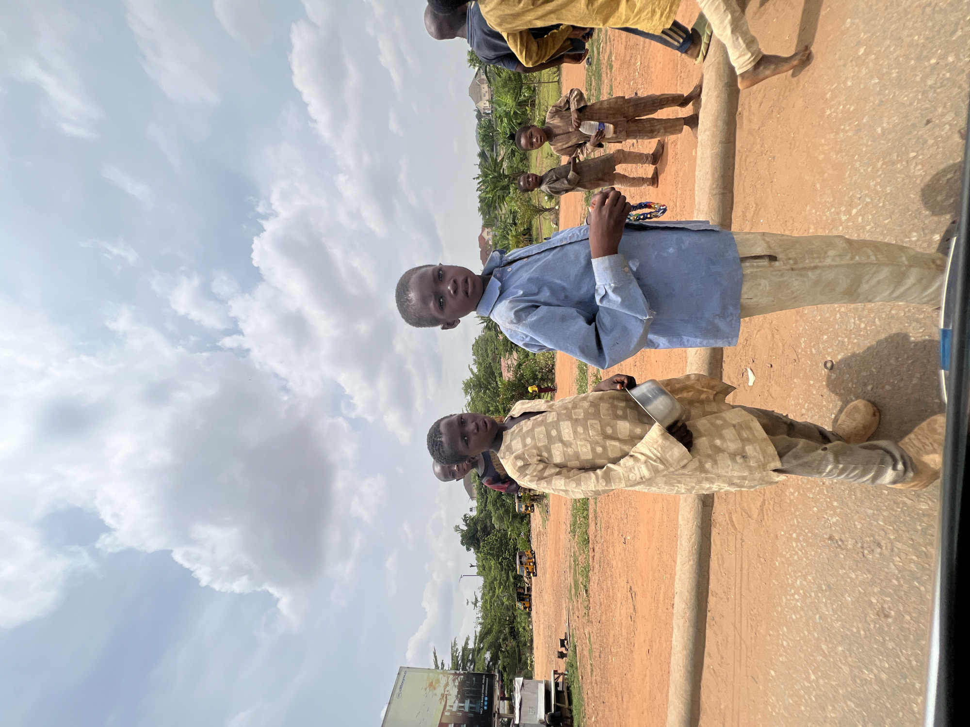 Young boys gather near dirt road in Abuja