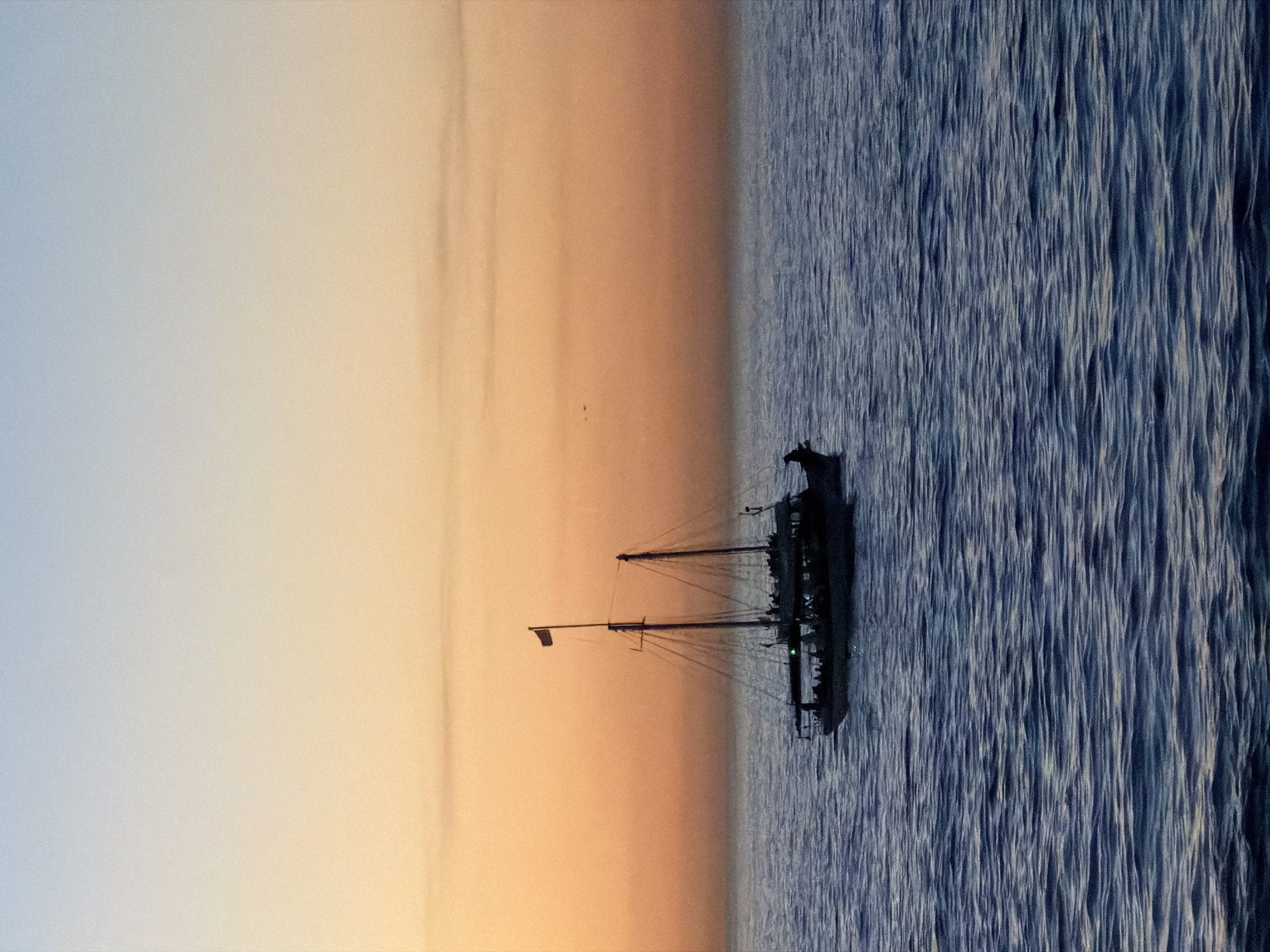 Sailboats navigate choppy Cape Town waters at sunset