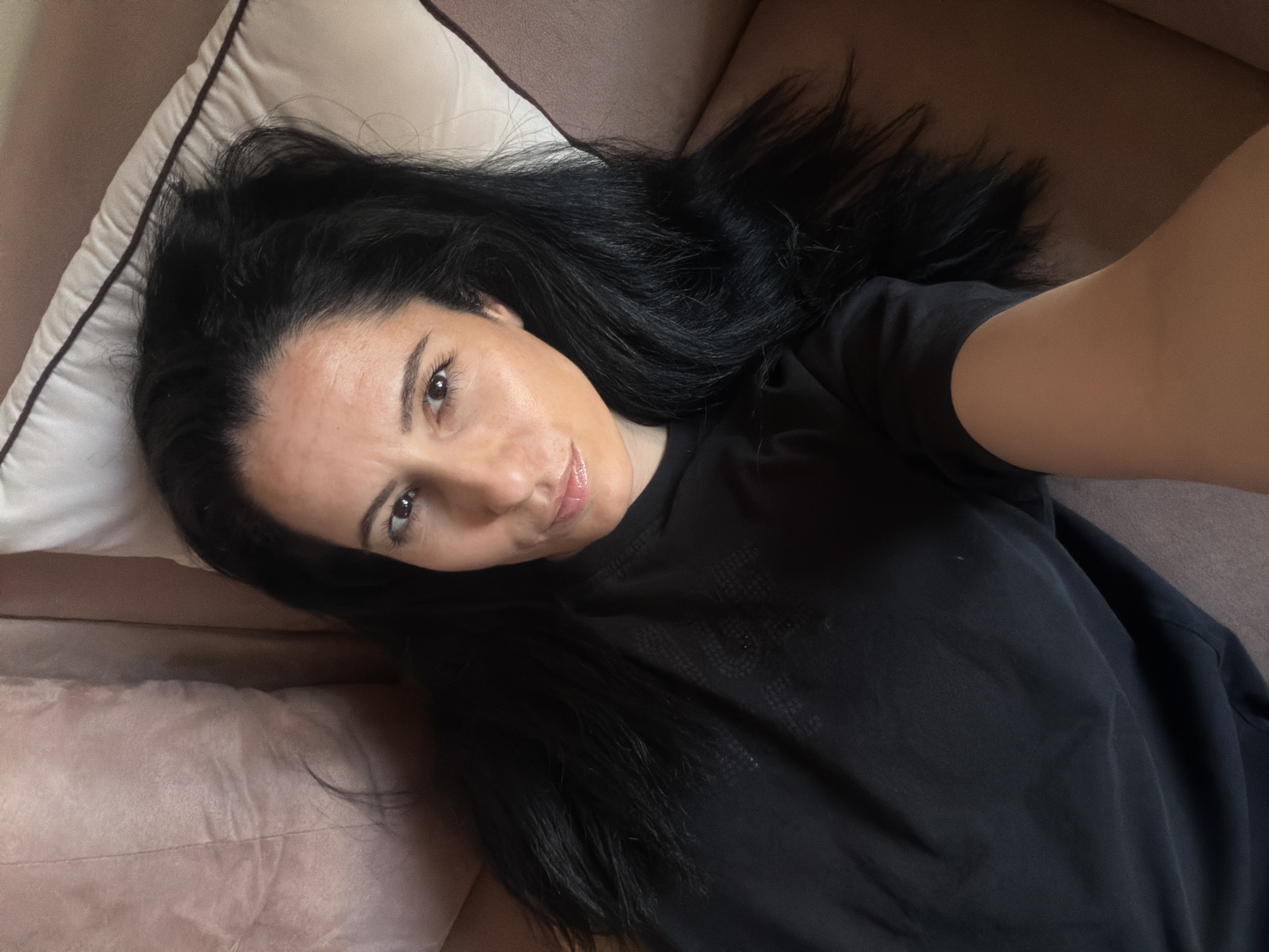 Woman takes selfies on pink couch in Pleven