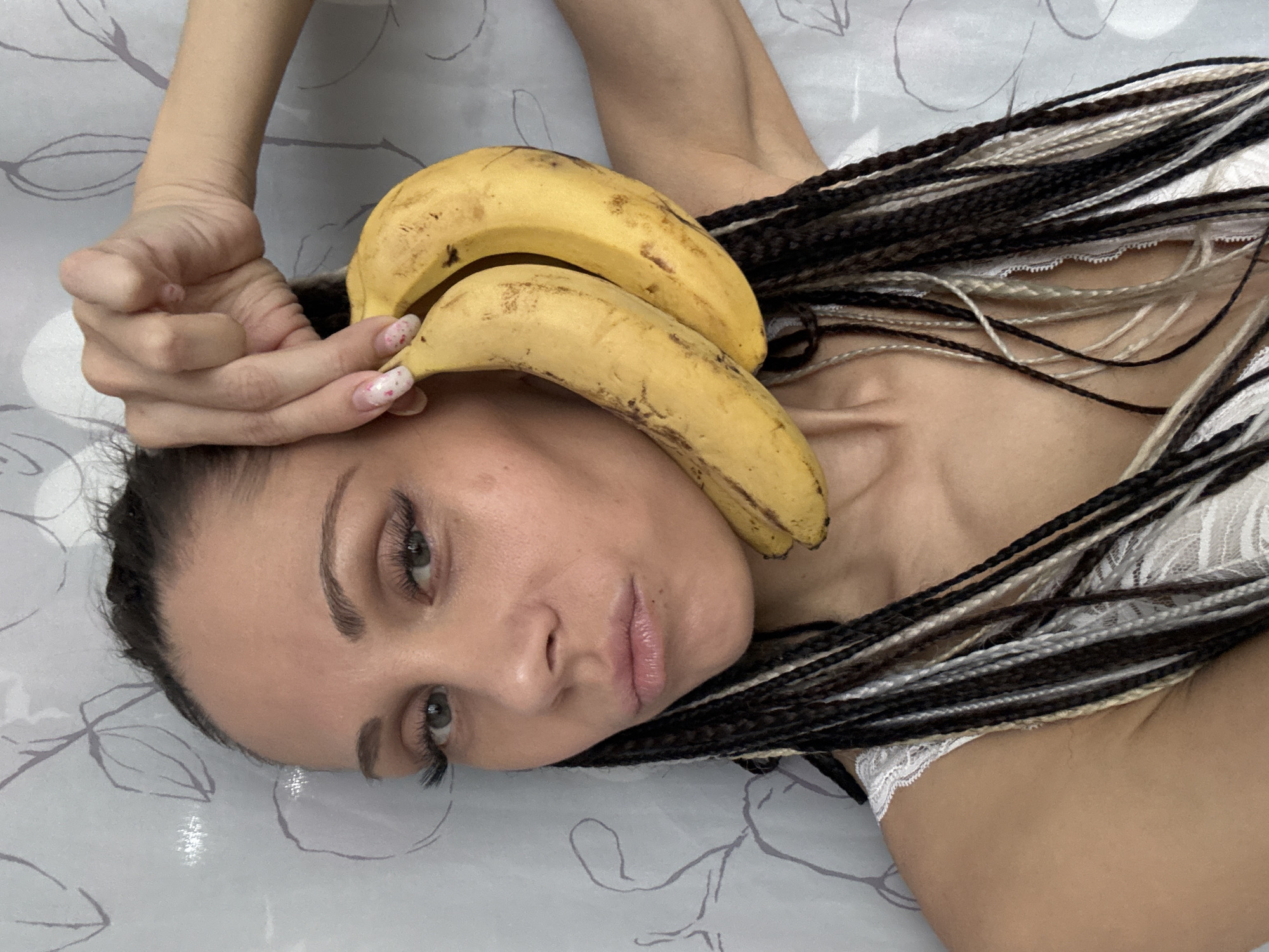 Woman poses playfully with bananas and plants in Rusanovo bedroom