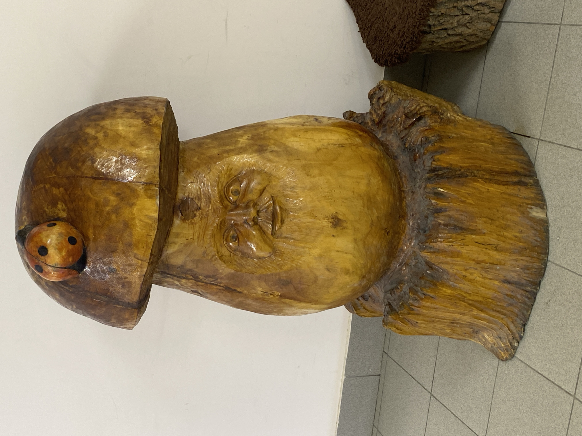 Large carved wooden sculpture with human face documented
