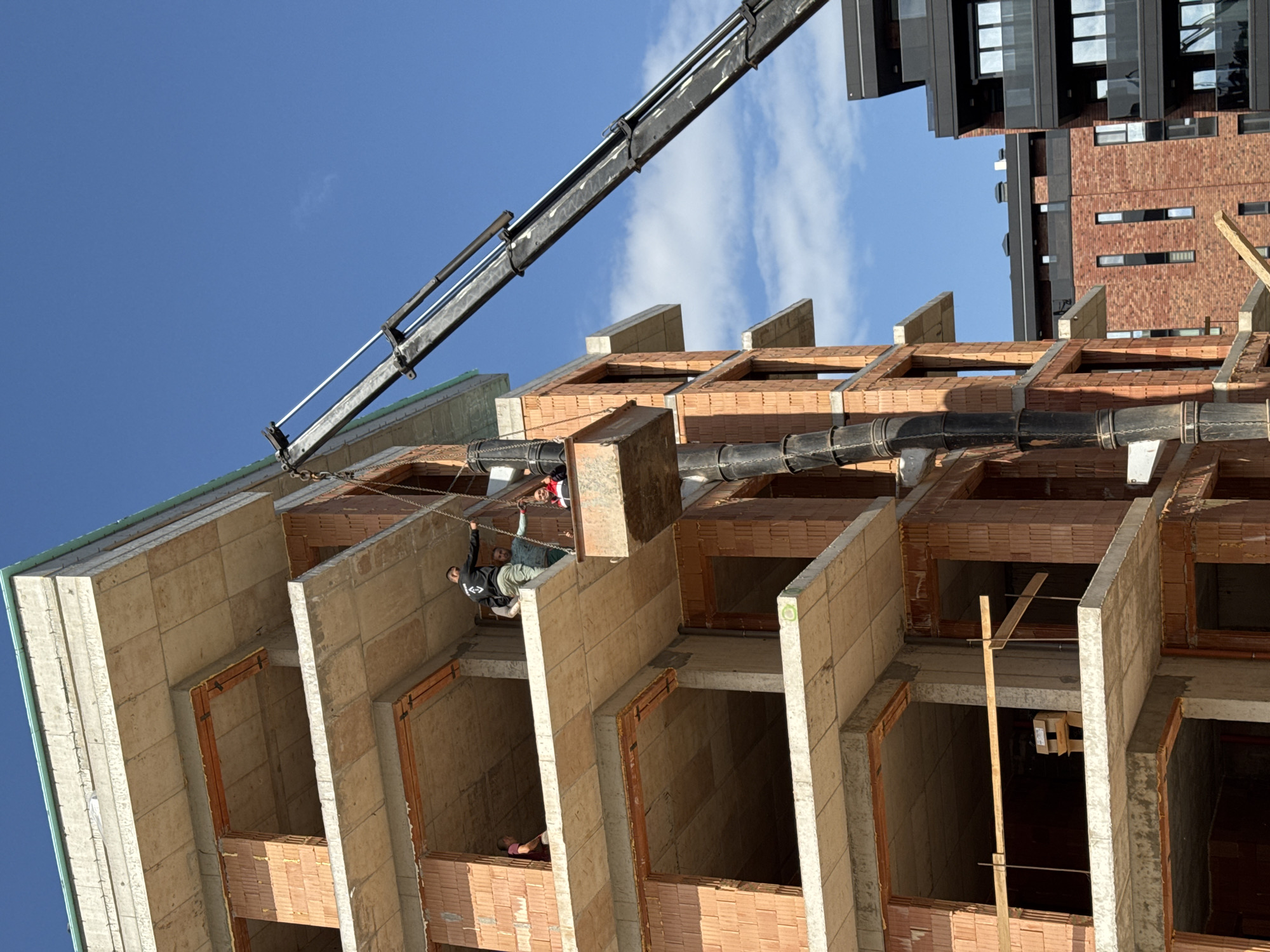 Construction site with multi-story building framework and crane documented