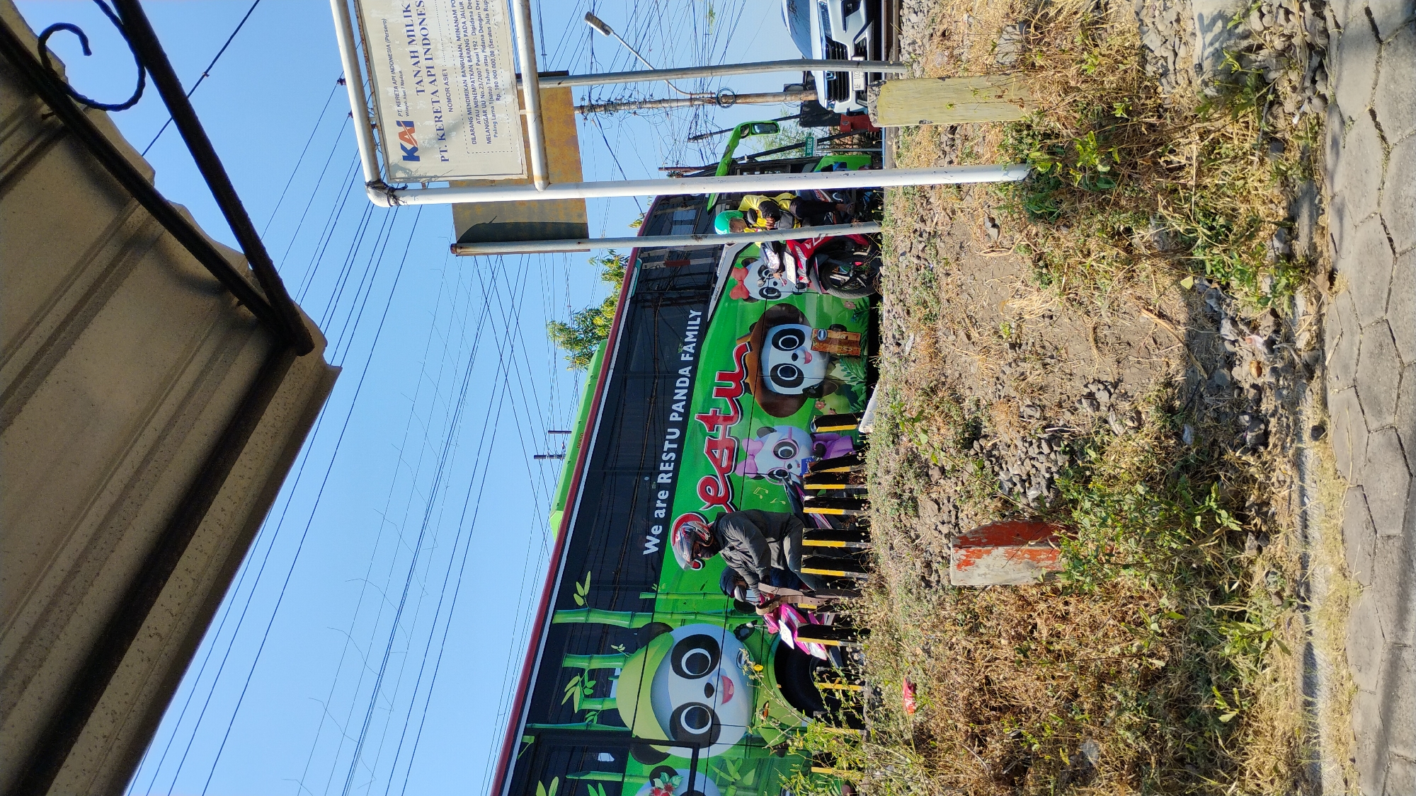 Train cuts through a busy street-level crossing in Madiun