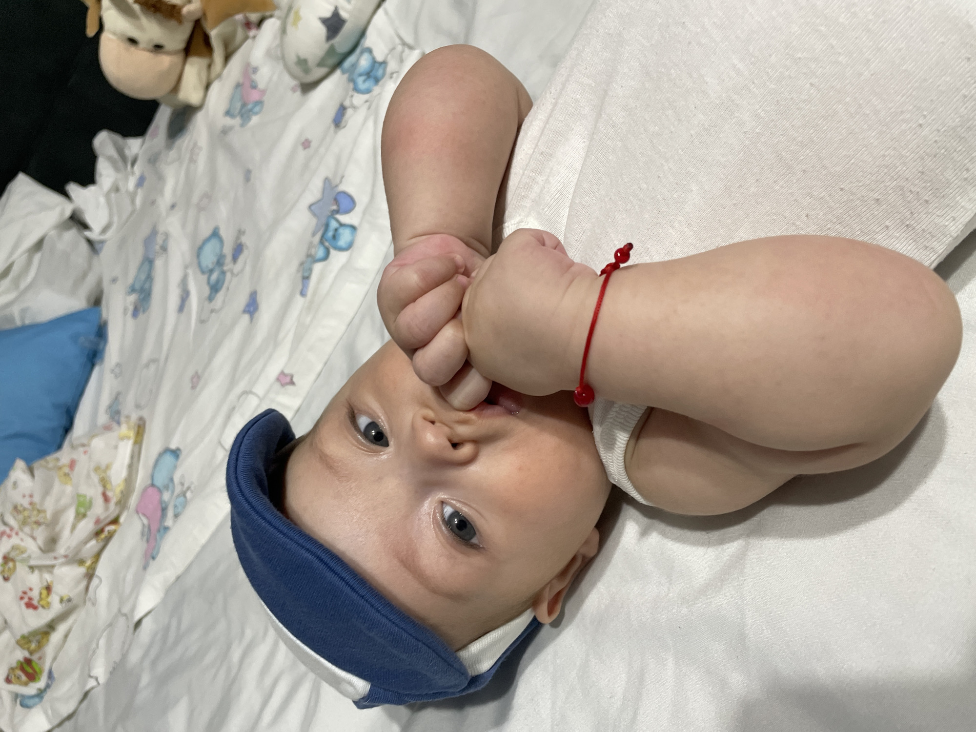 Baby on patterned sheet, two angles, Fălești