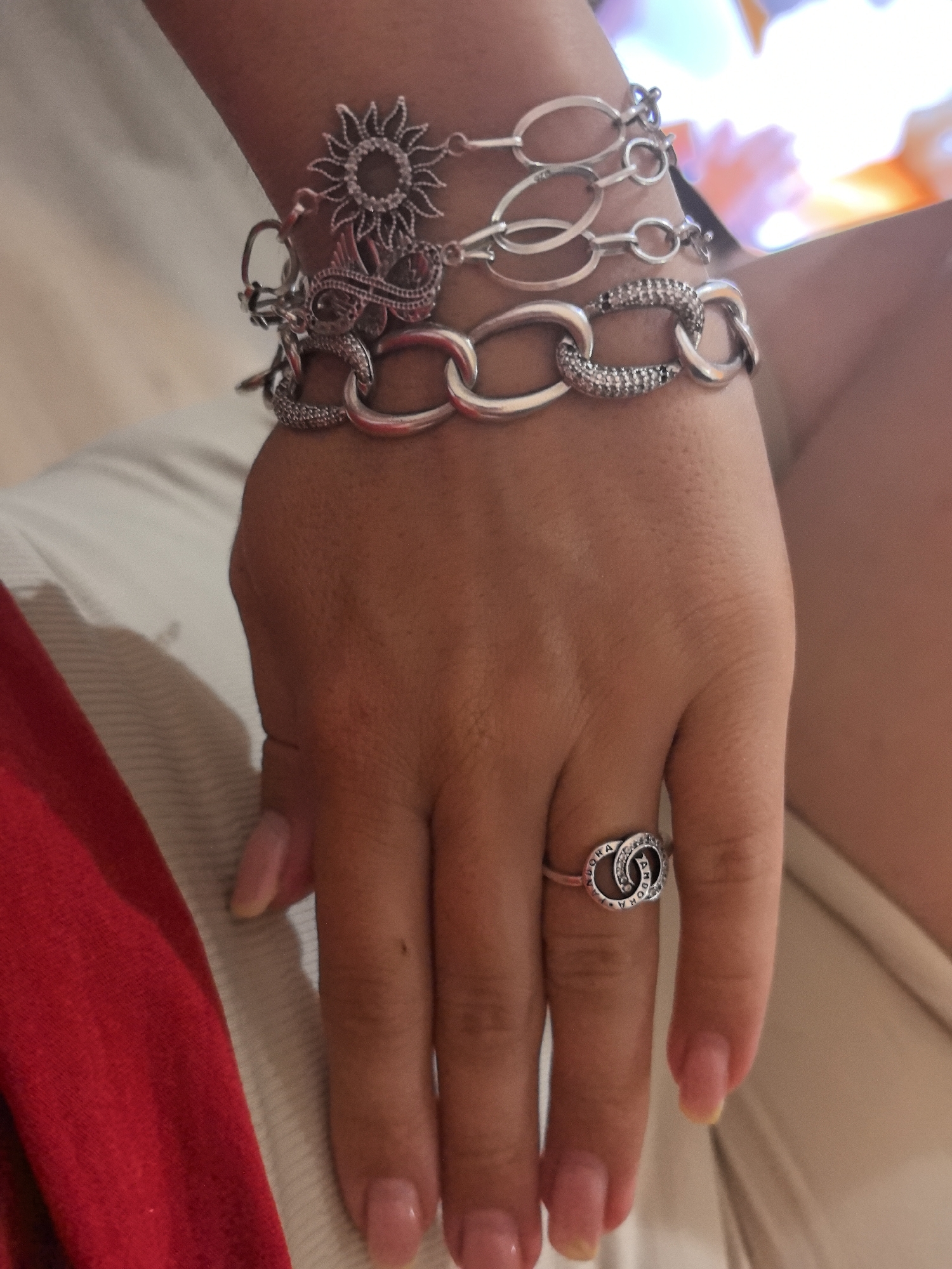 Silver bracelet stack and ring on a left wrist