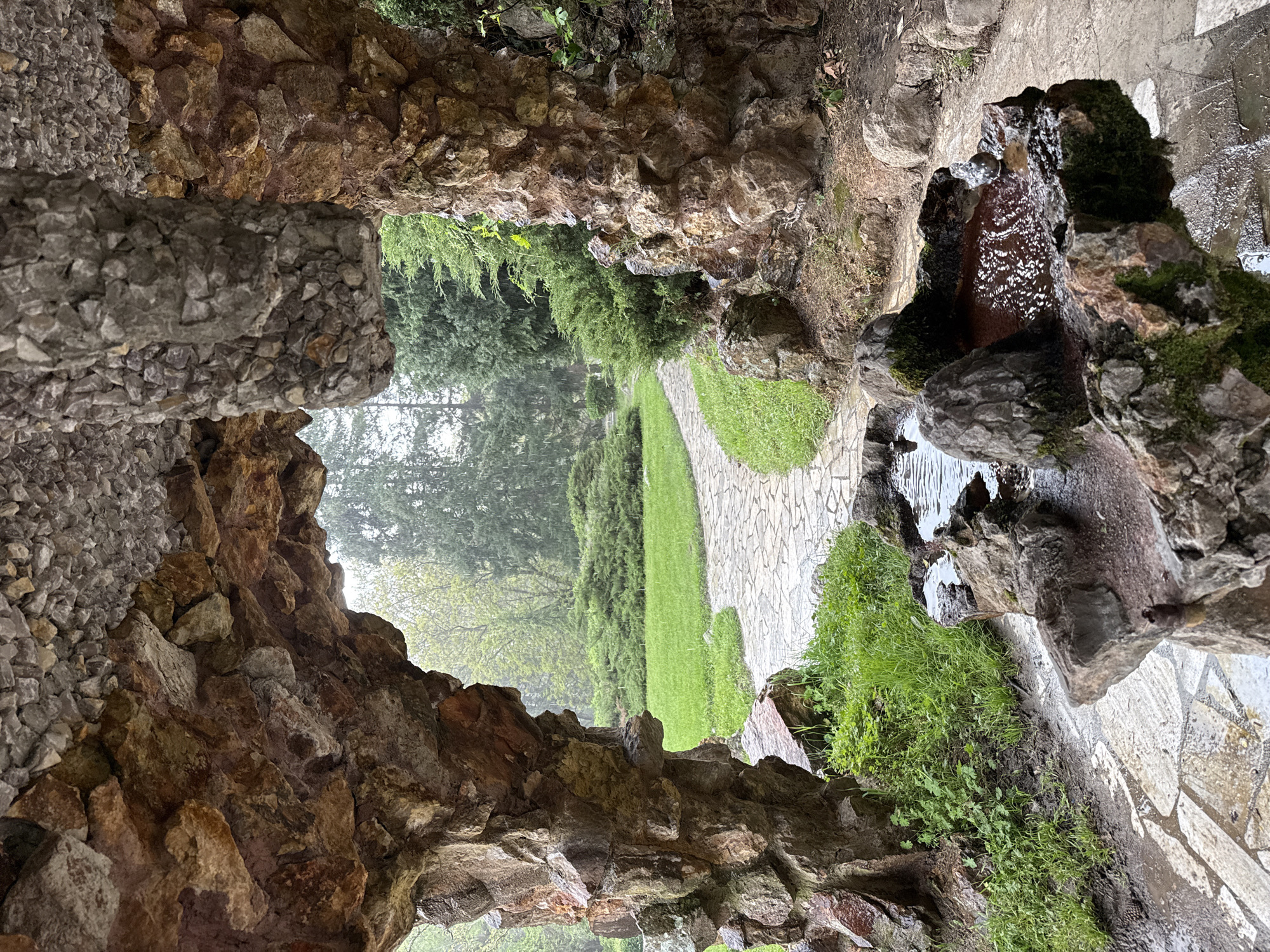 Rocky cave opening frames park view at unknown location