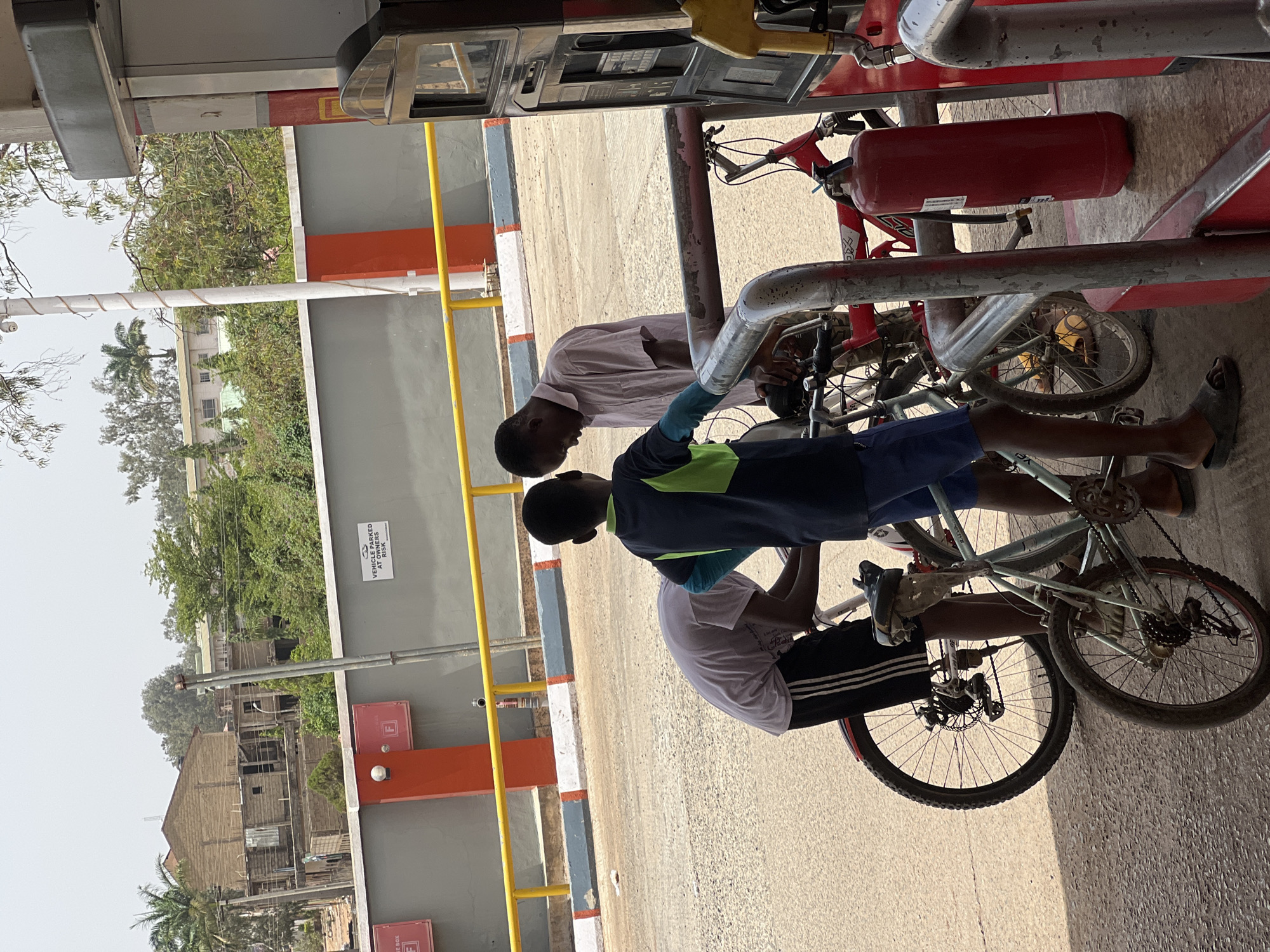 Two cyclists visit petrol station in Jos, Nigeria